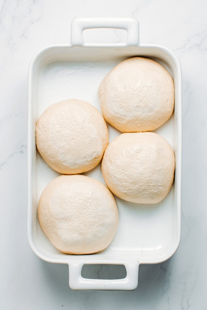 Pizza dough after rising, in a baking dish.