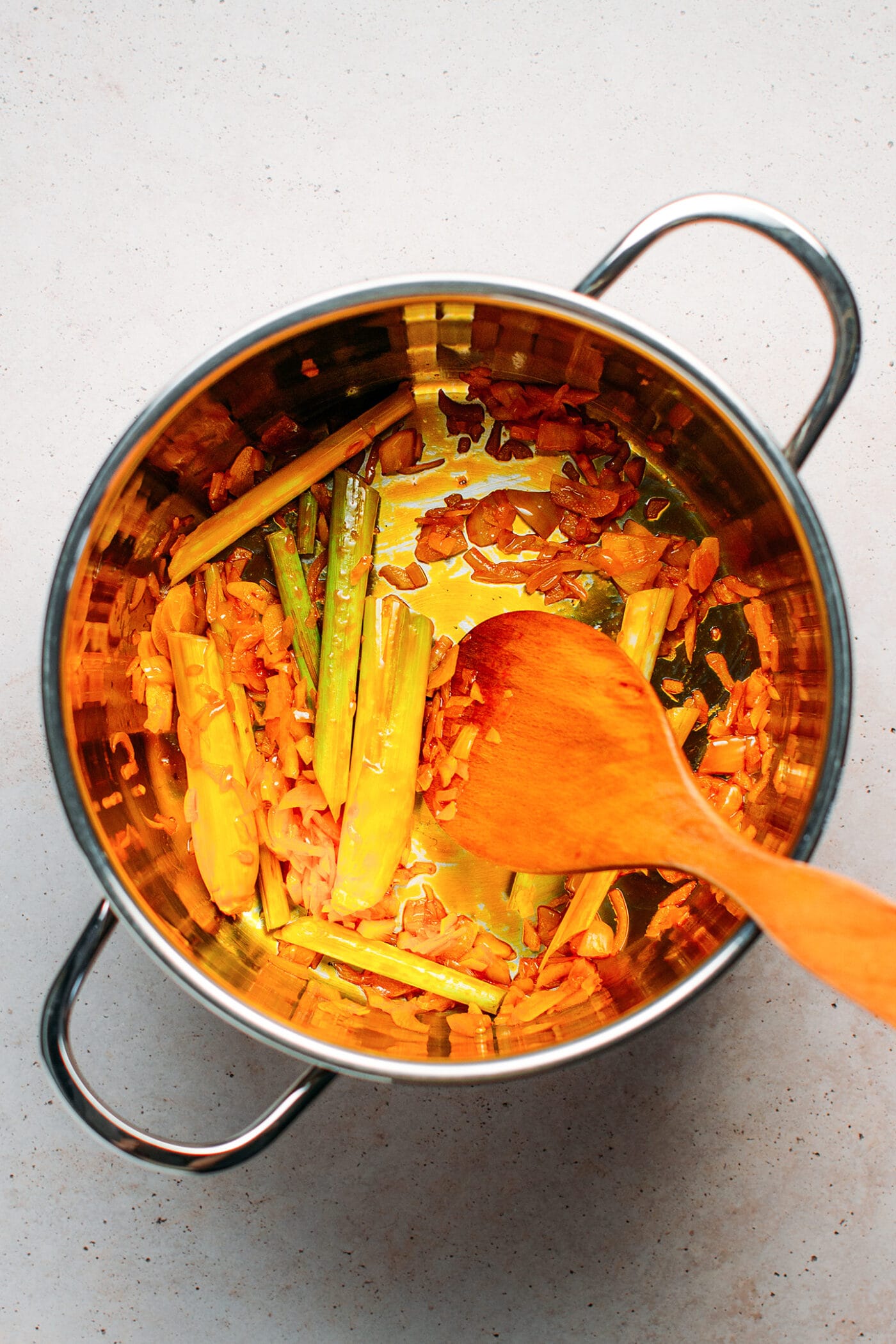 Sautéing lemongrass and shallots in a pot.