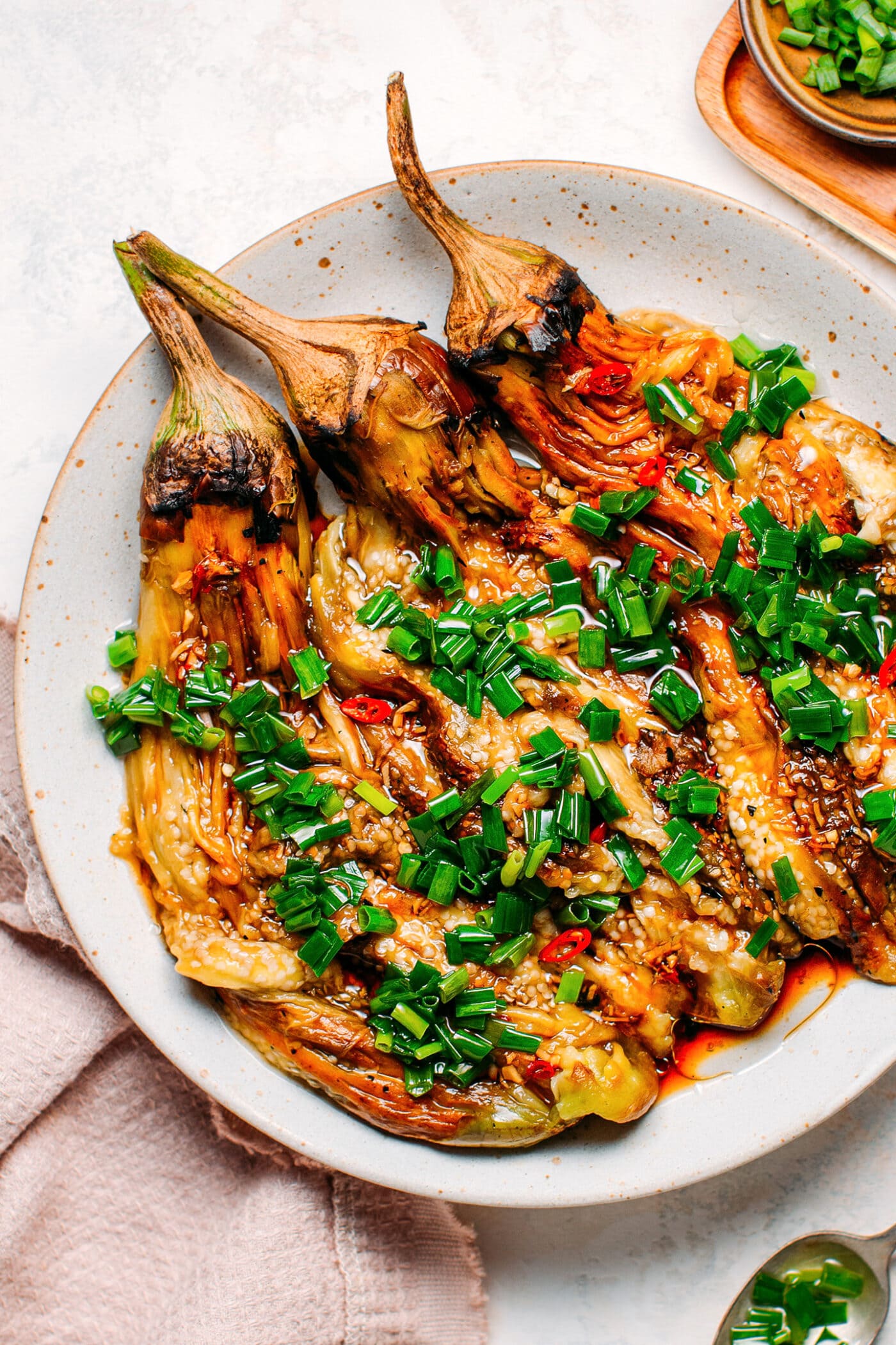 Grilled eggplants topped with green onions, garlic, and chili.