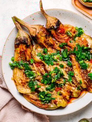 Grilled eggplants topped with green onions, garlic, and chili.