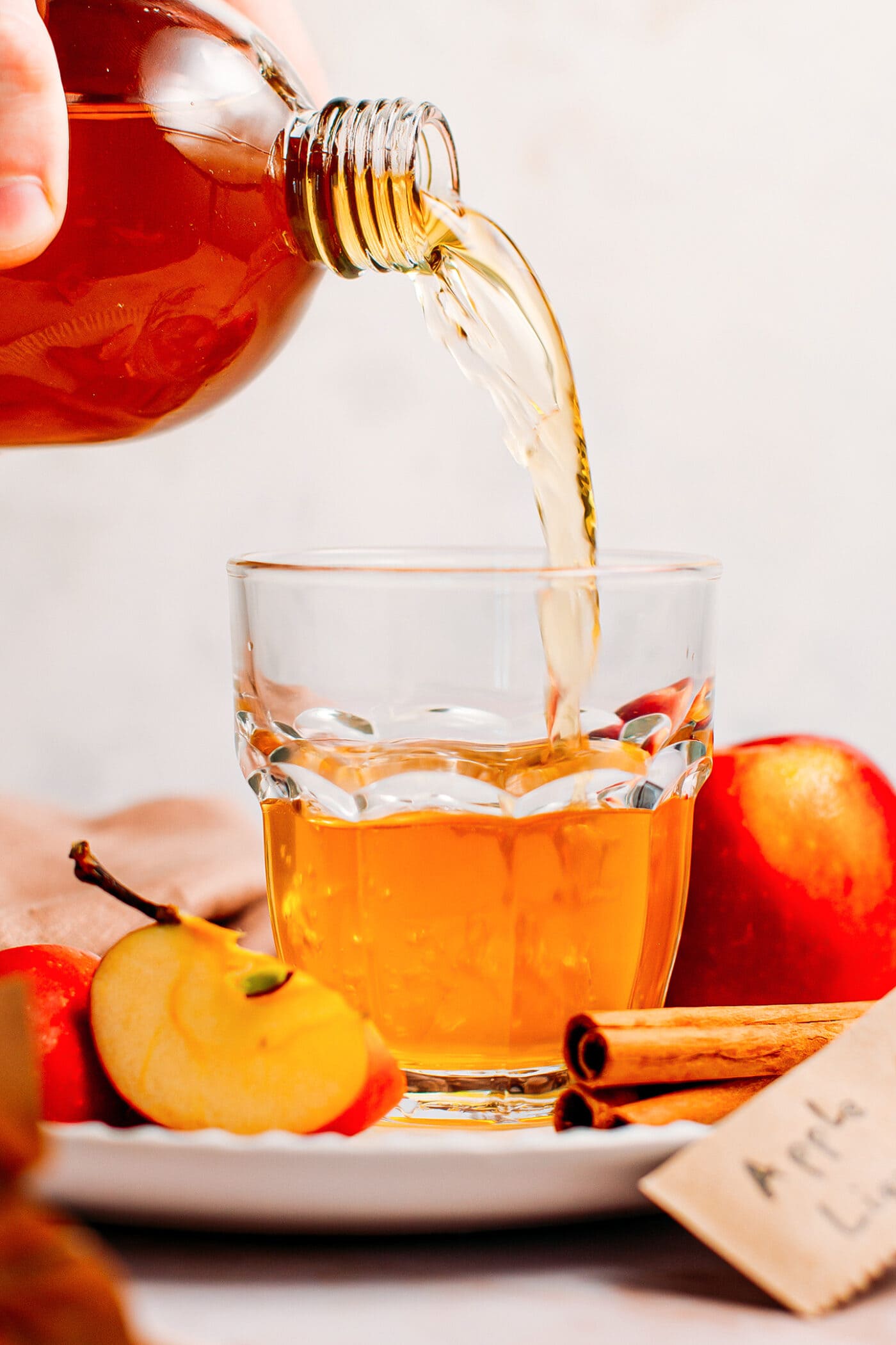 Pouring homemade apple liquor into a glass.