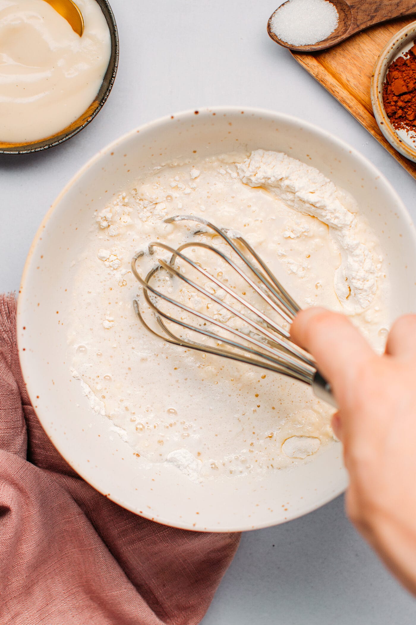 Whisking flour and almond milk to make pancakes.