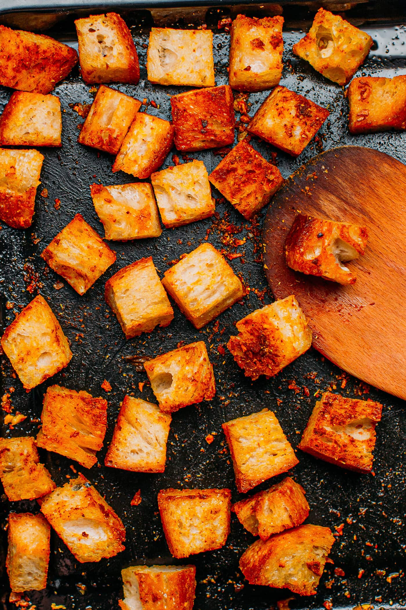 Baked croutons with curry powder on a baking sheet.