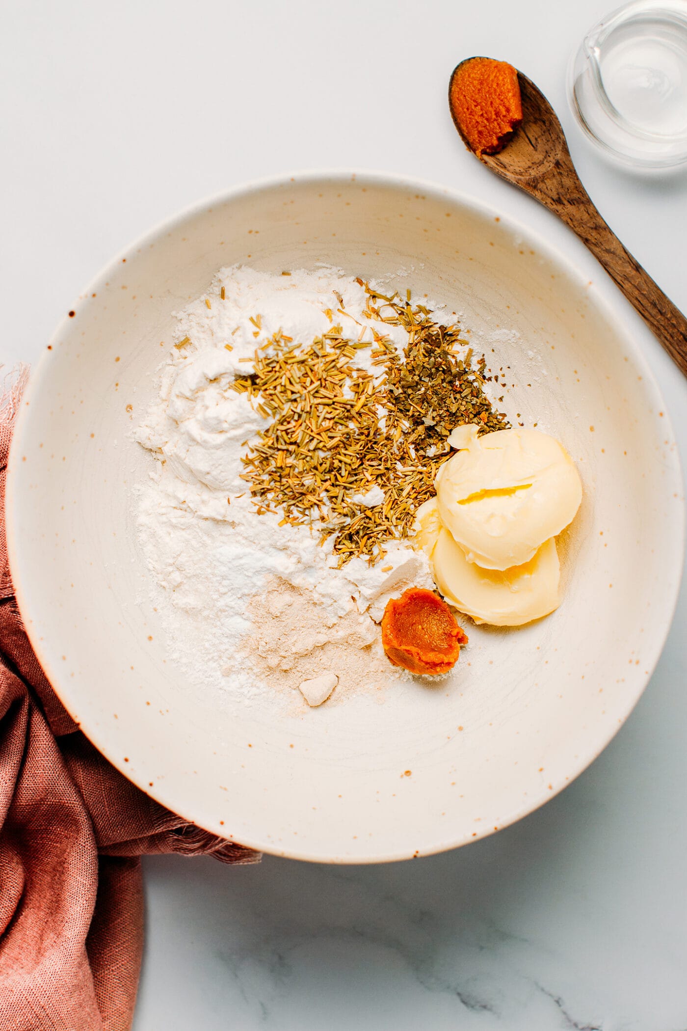 Flour, dried herbs, butter, miso, onion powder, and salt in a bowl.