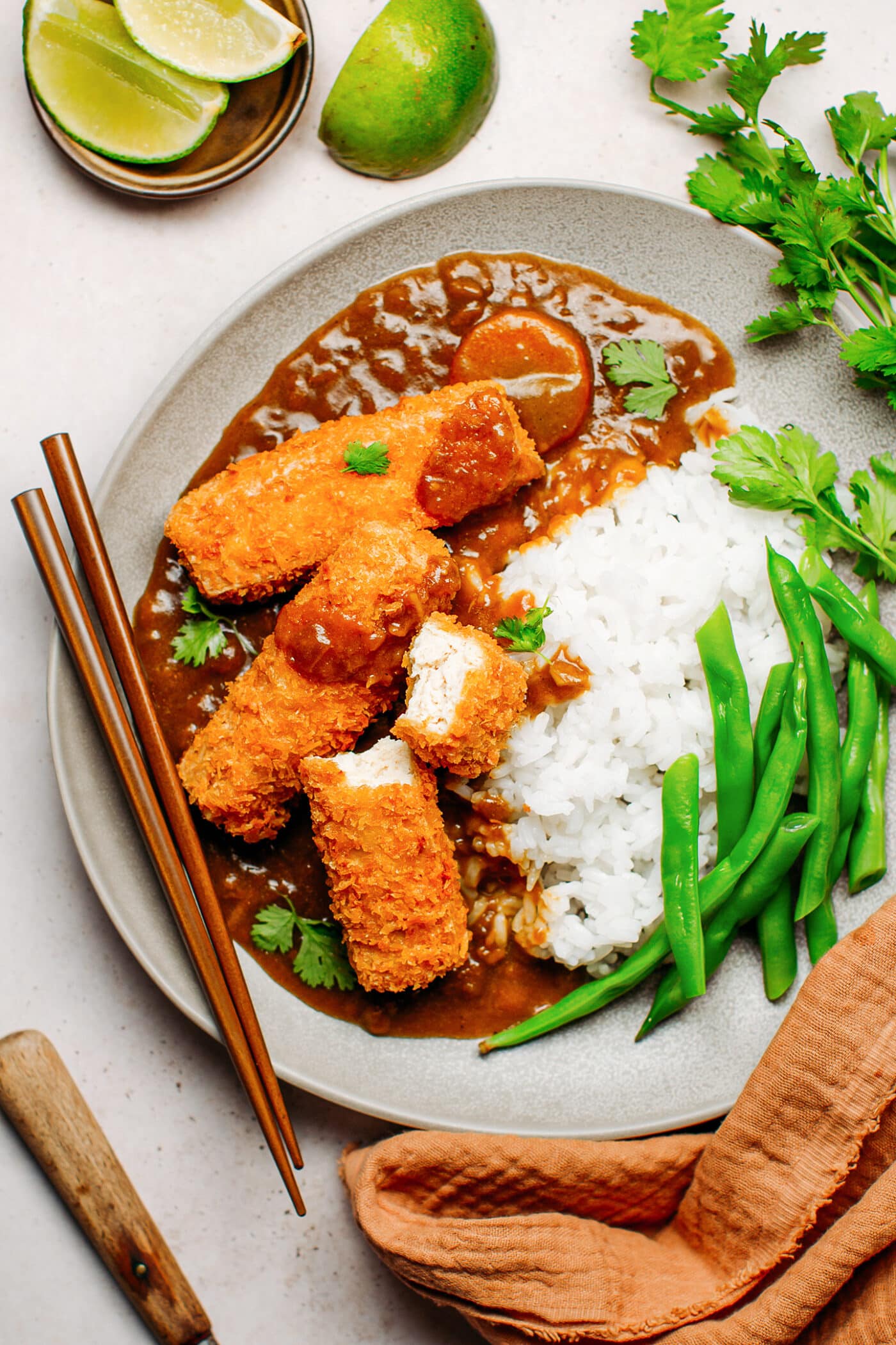 Panko katsu tofu with curry sauce, white rice, and green beans.