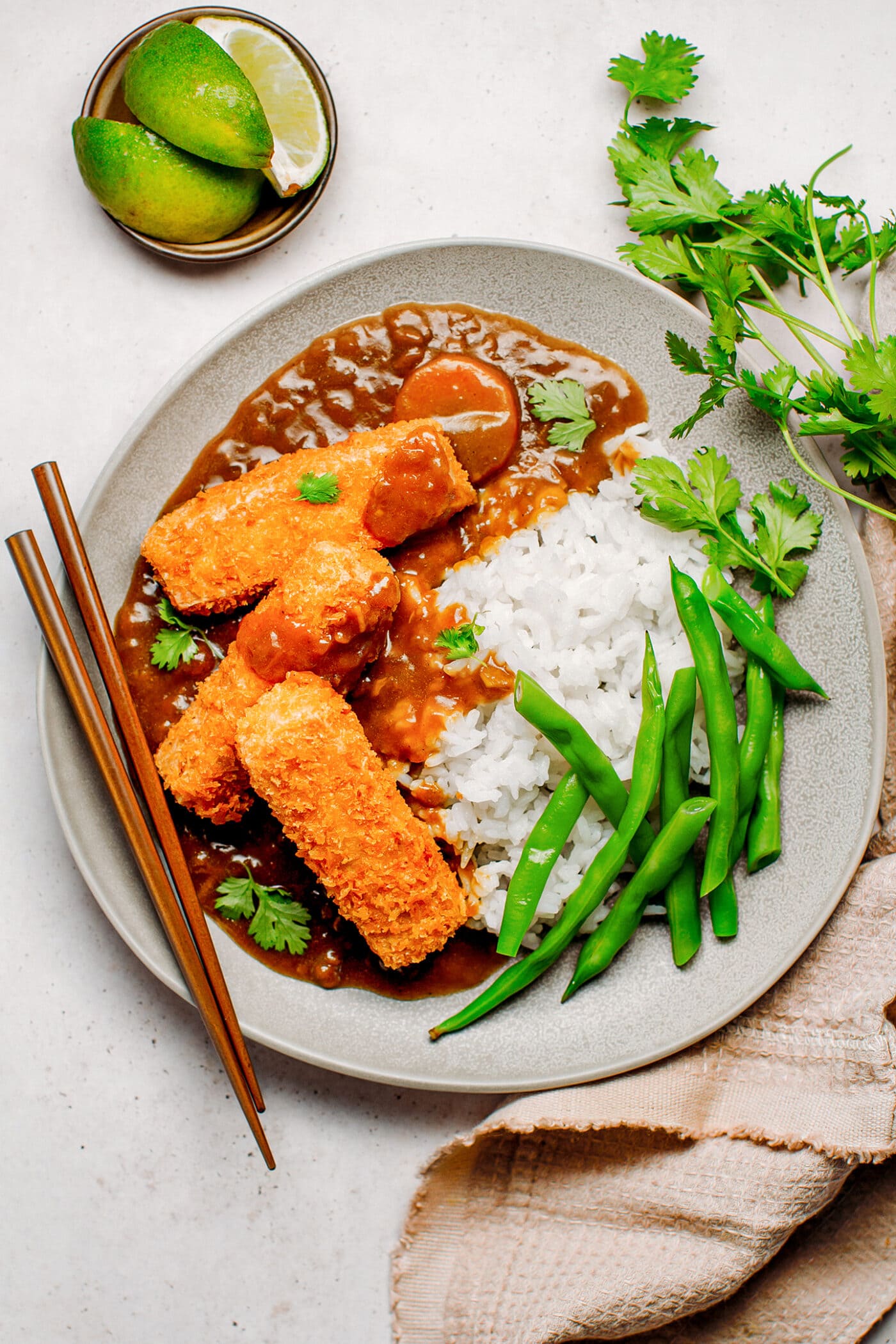 Panko katsu tofu with curry sauce, white rice, and green beans.