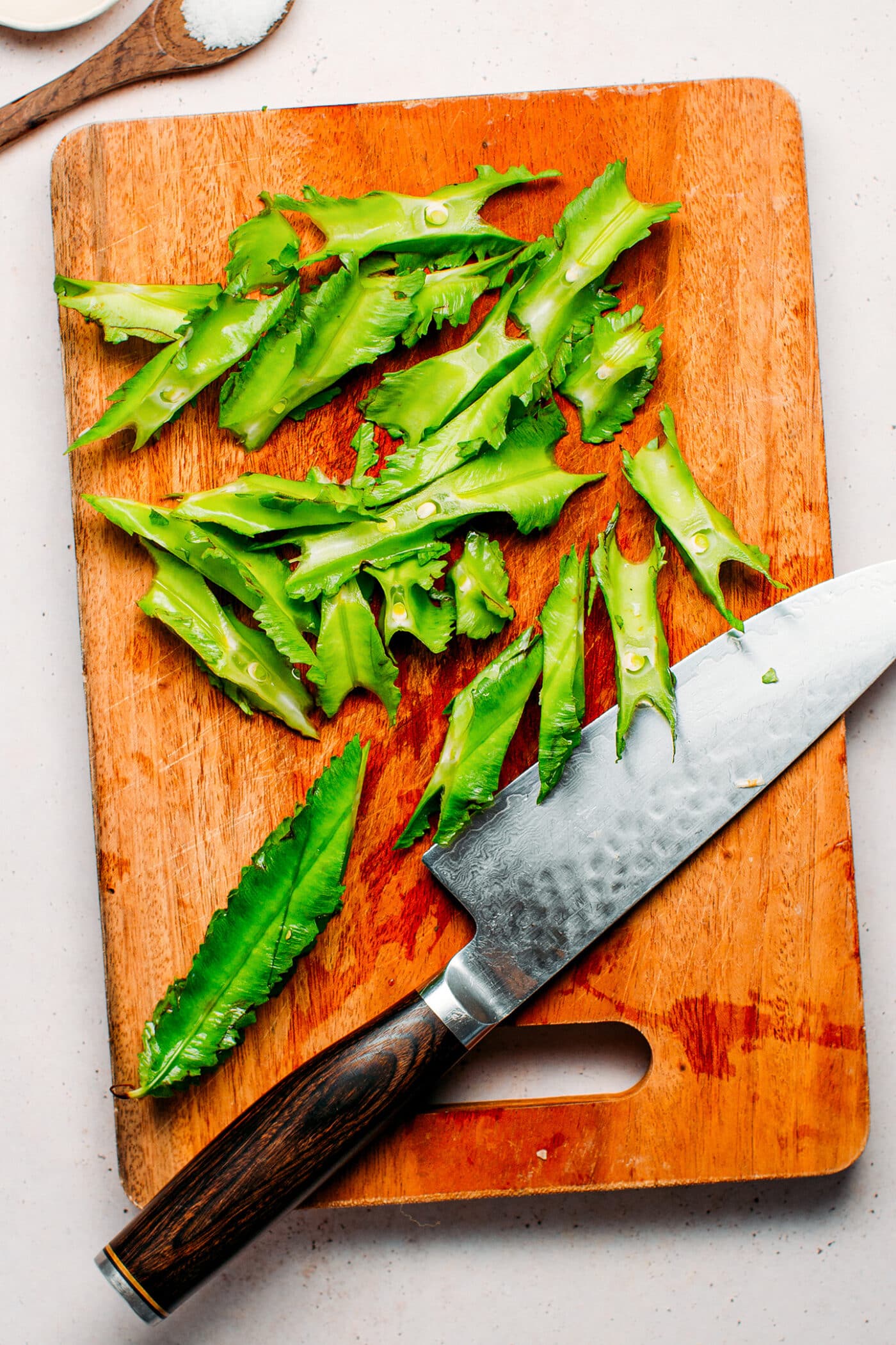 Sliced winged beans on a cutting board.