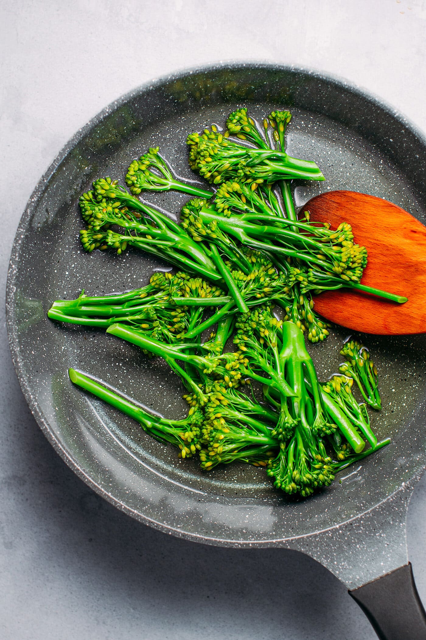 Steamed broccolini in a skillet.