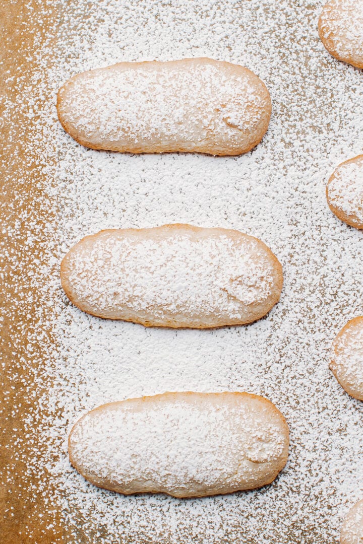 Baked vegan ladyfingers on a baking sheet.