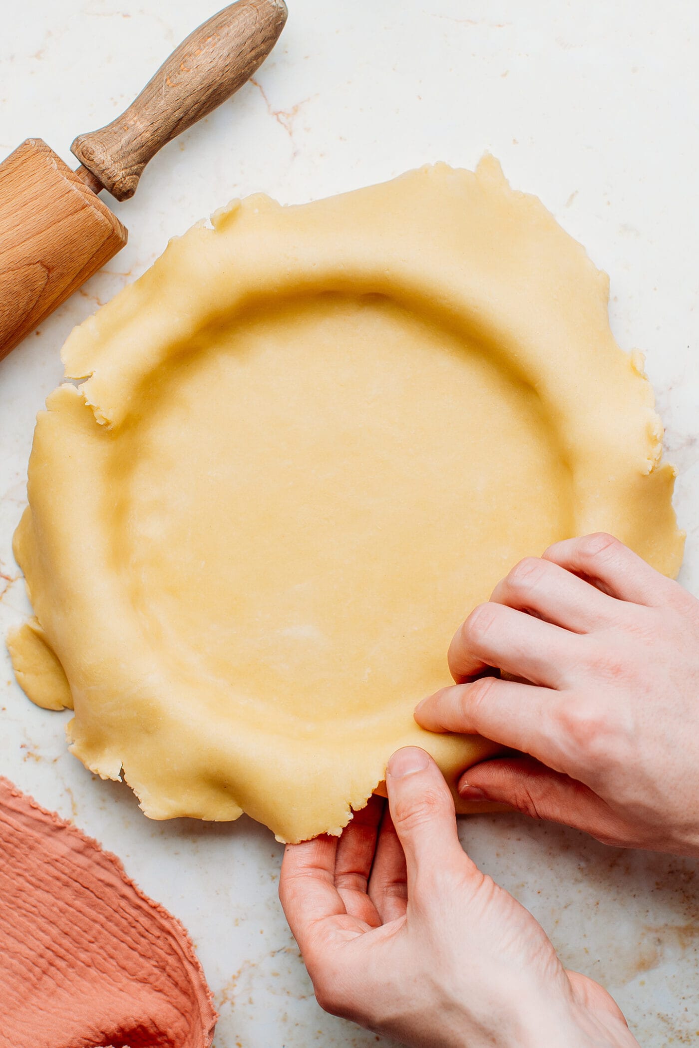 Filling a pie plate with homemade pie crust.