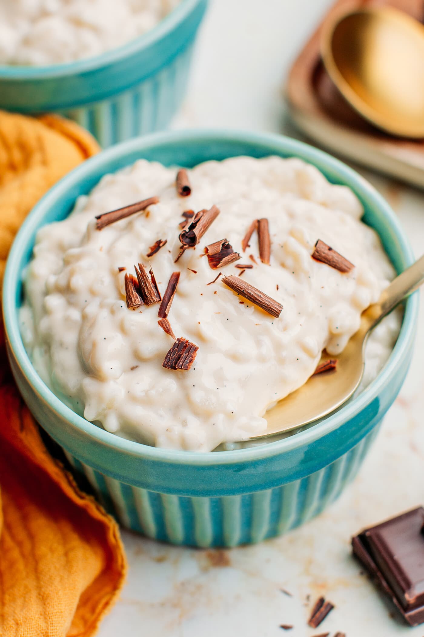 Rice pudding topped with shaved chocolate in a ramekin.