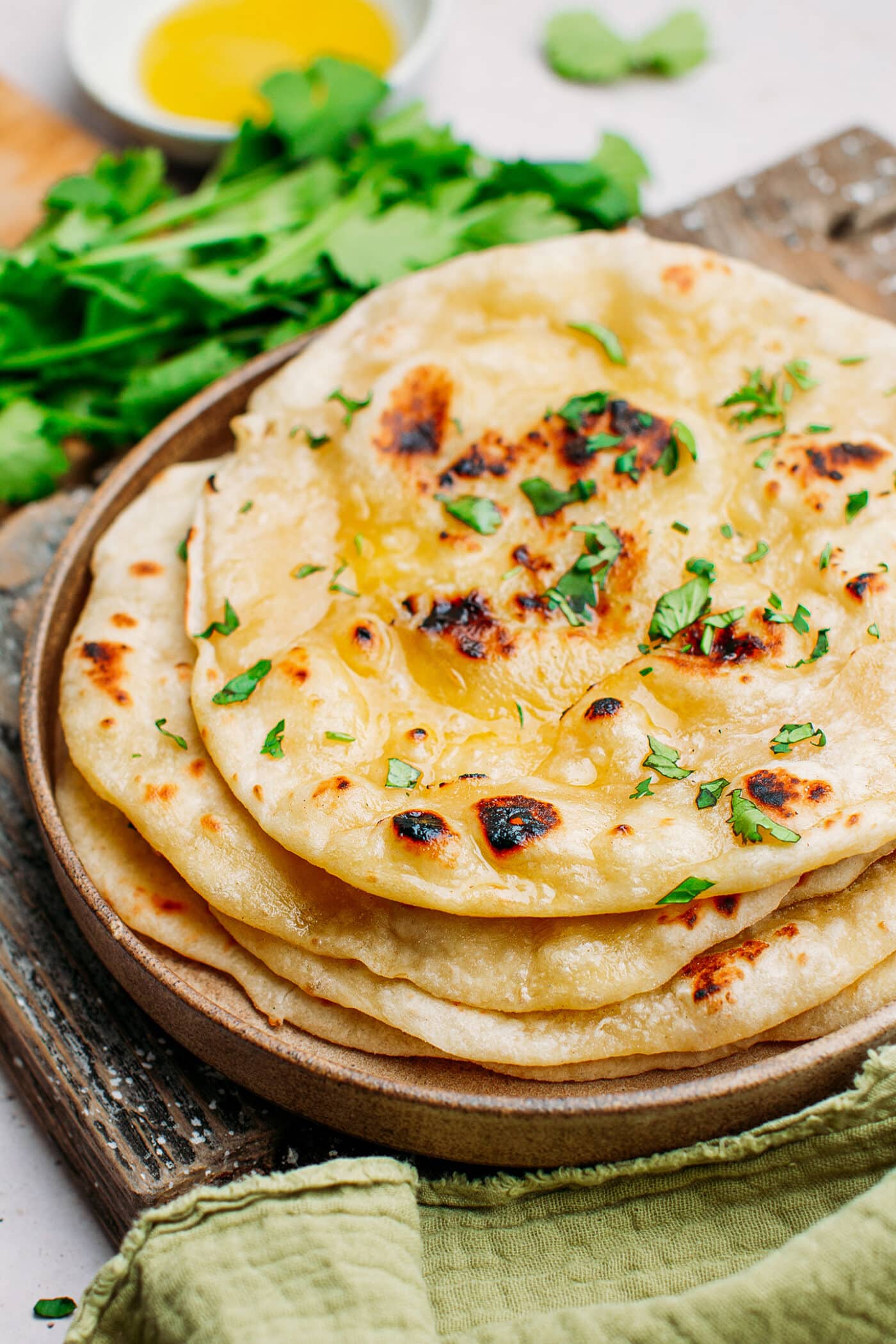 Close-up of naan brushed with butter and topped with cilantro.