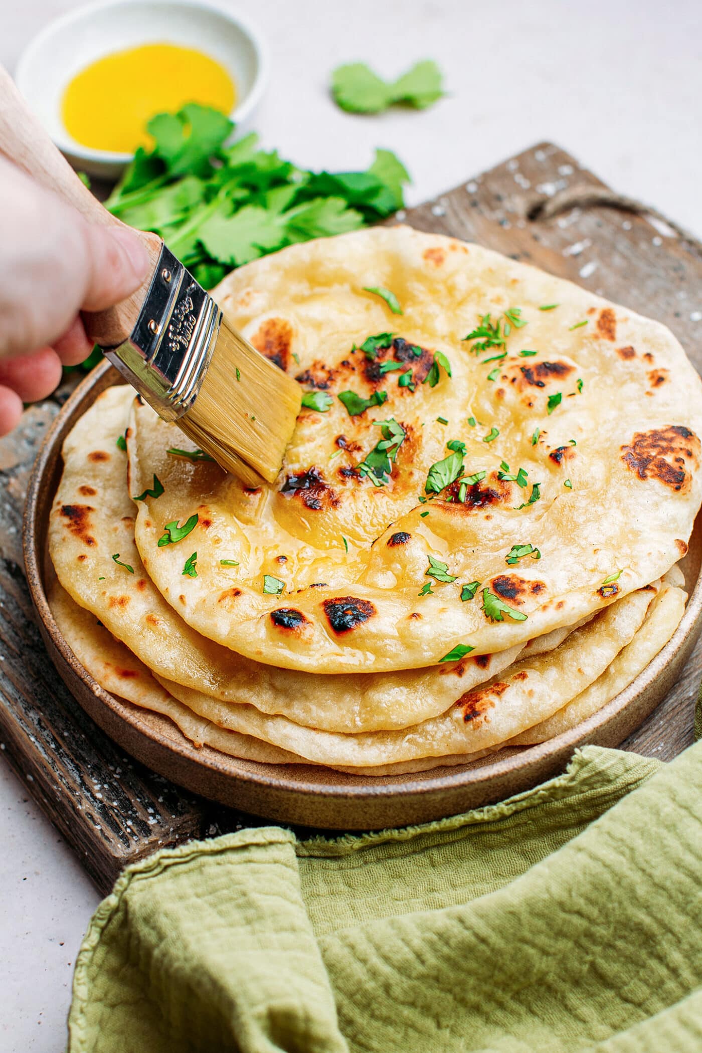 Brushing naan with butter.