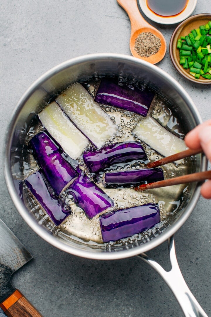 Deep-frying Chinese eggplants.