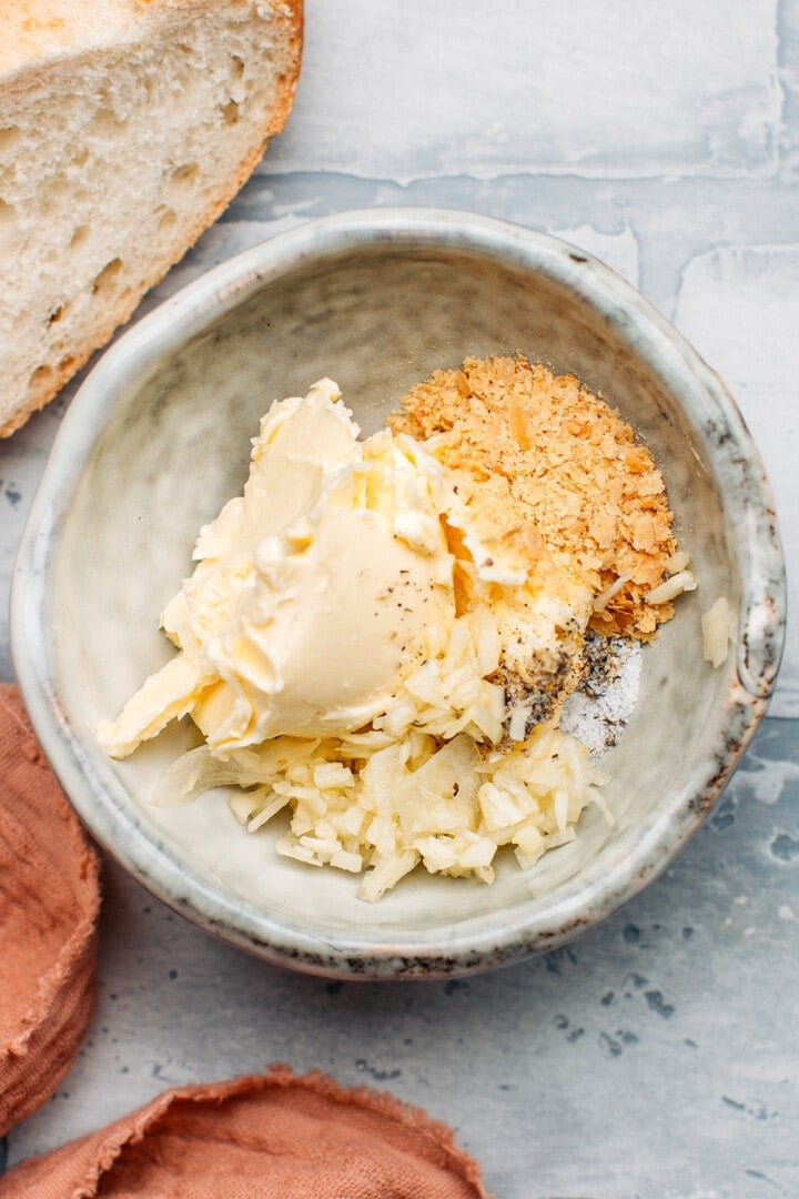 Butter, minced garlic, and nutritional yeast in a bowl.