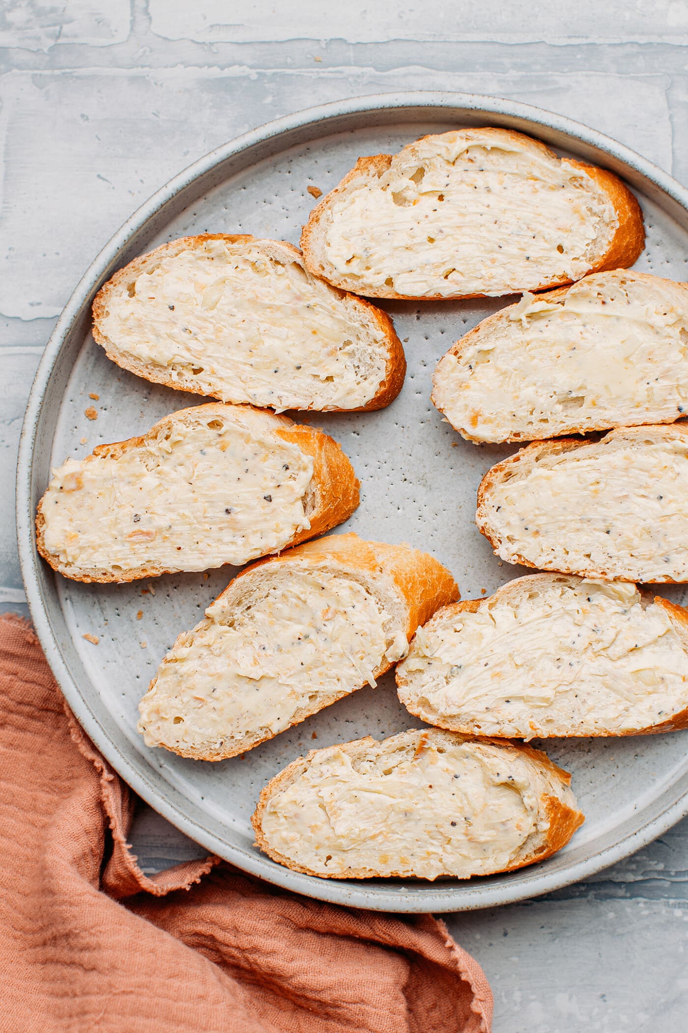 Slices of bread with garlic butter in a plate.