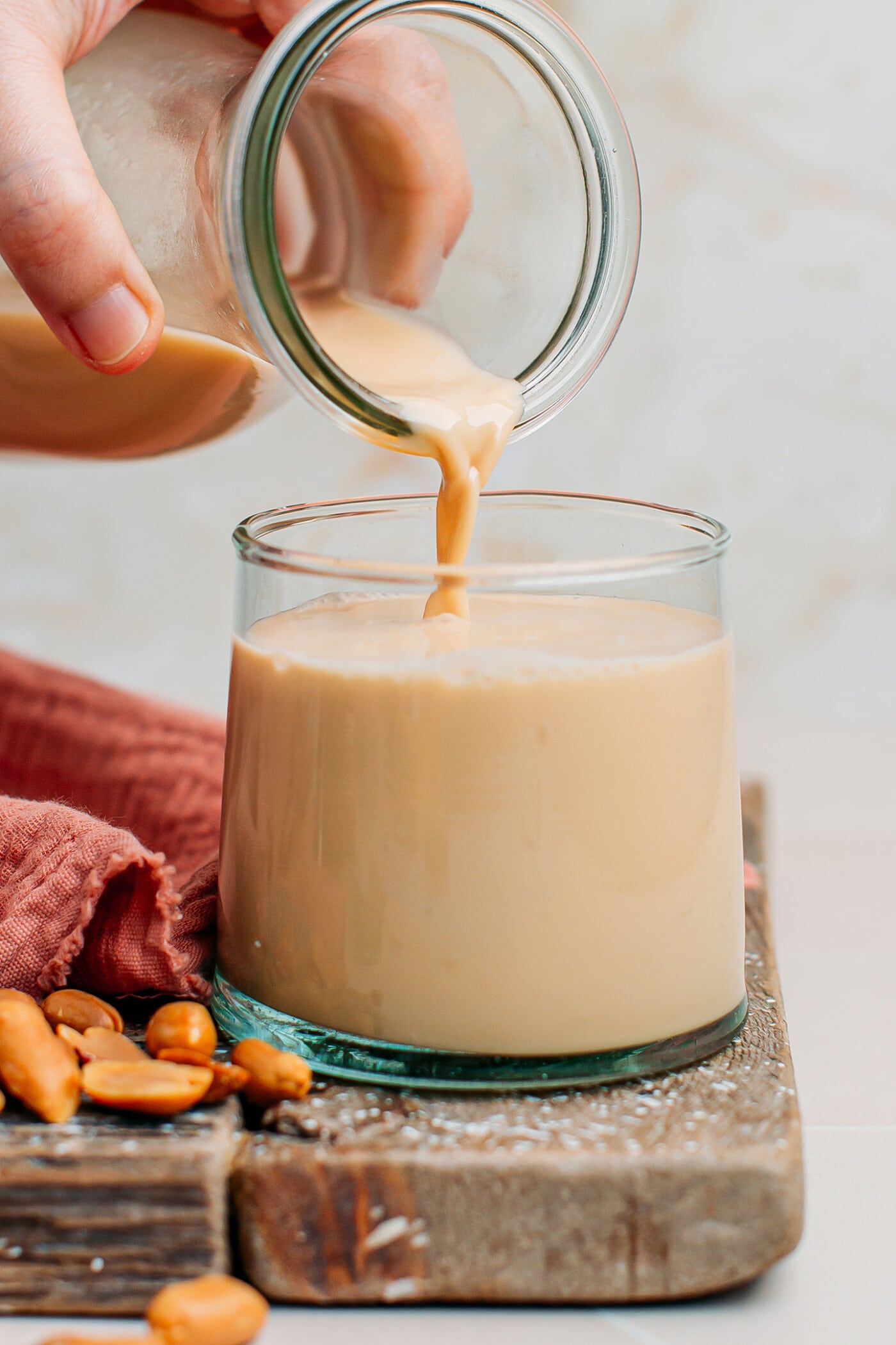 Pouring peanut milk into a glass.