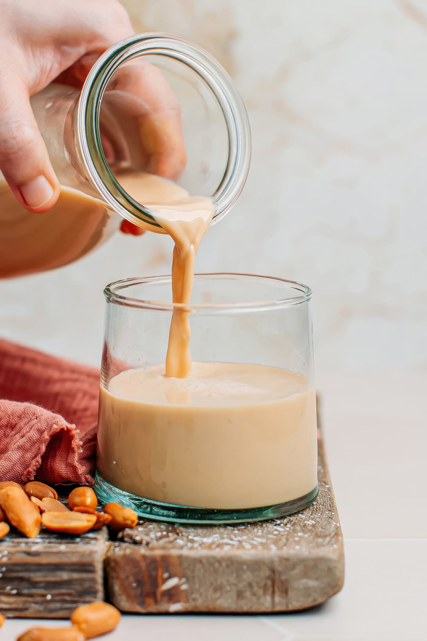 Pouring peanut milk into a glass.