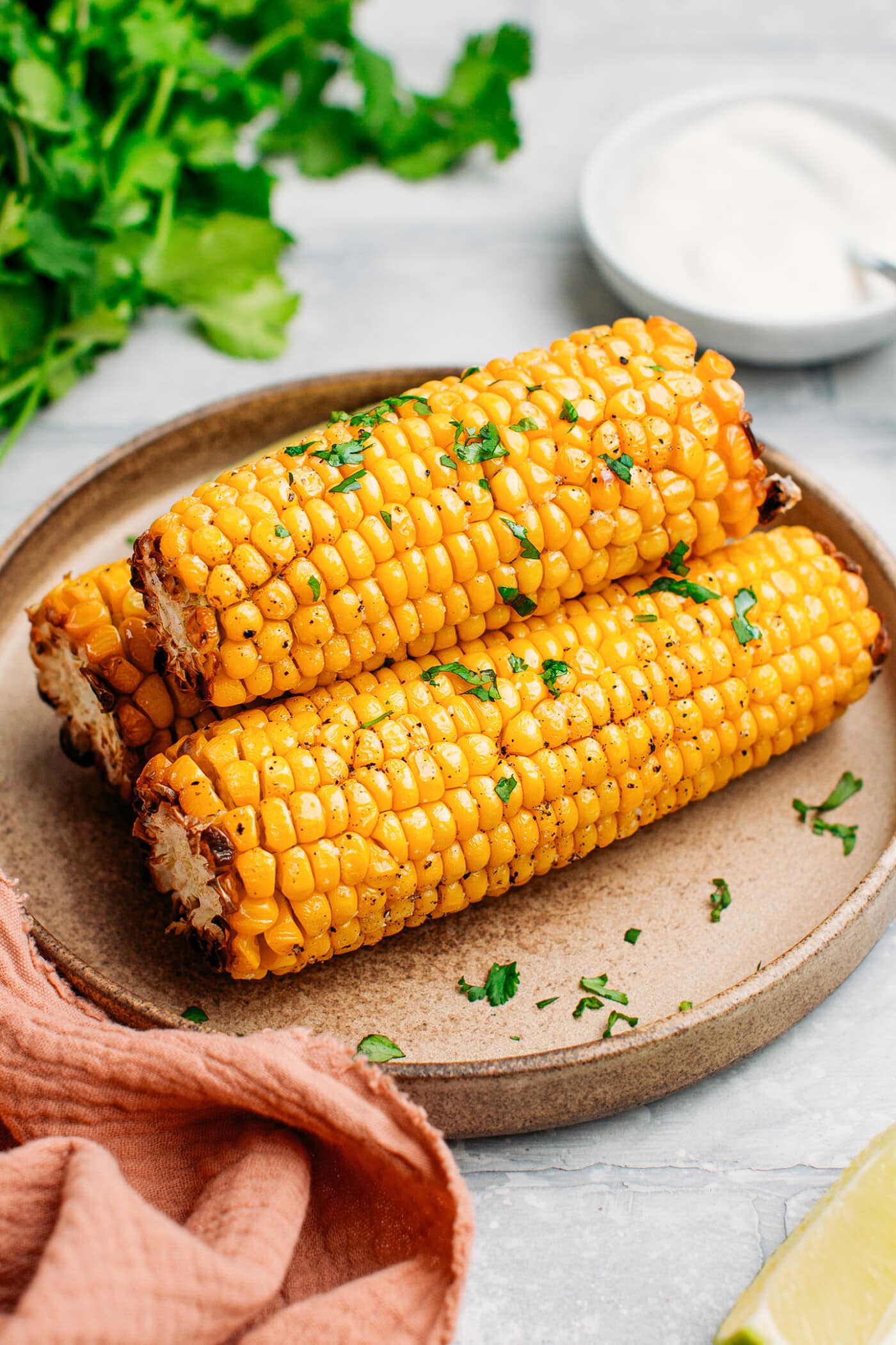 Corn on the cob topped with chopped cilantro.