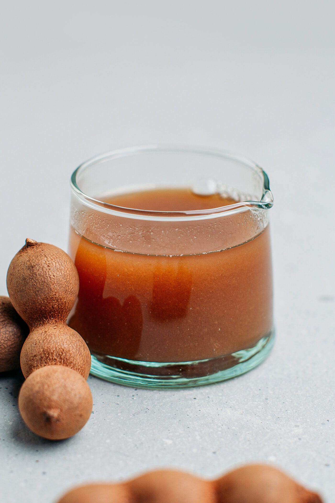 Tamarind juice in a small glass cup.