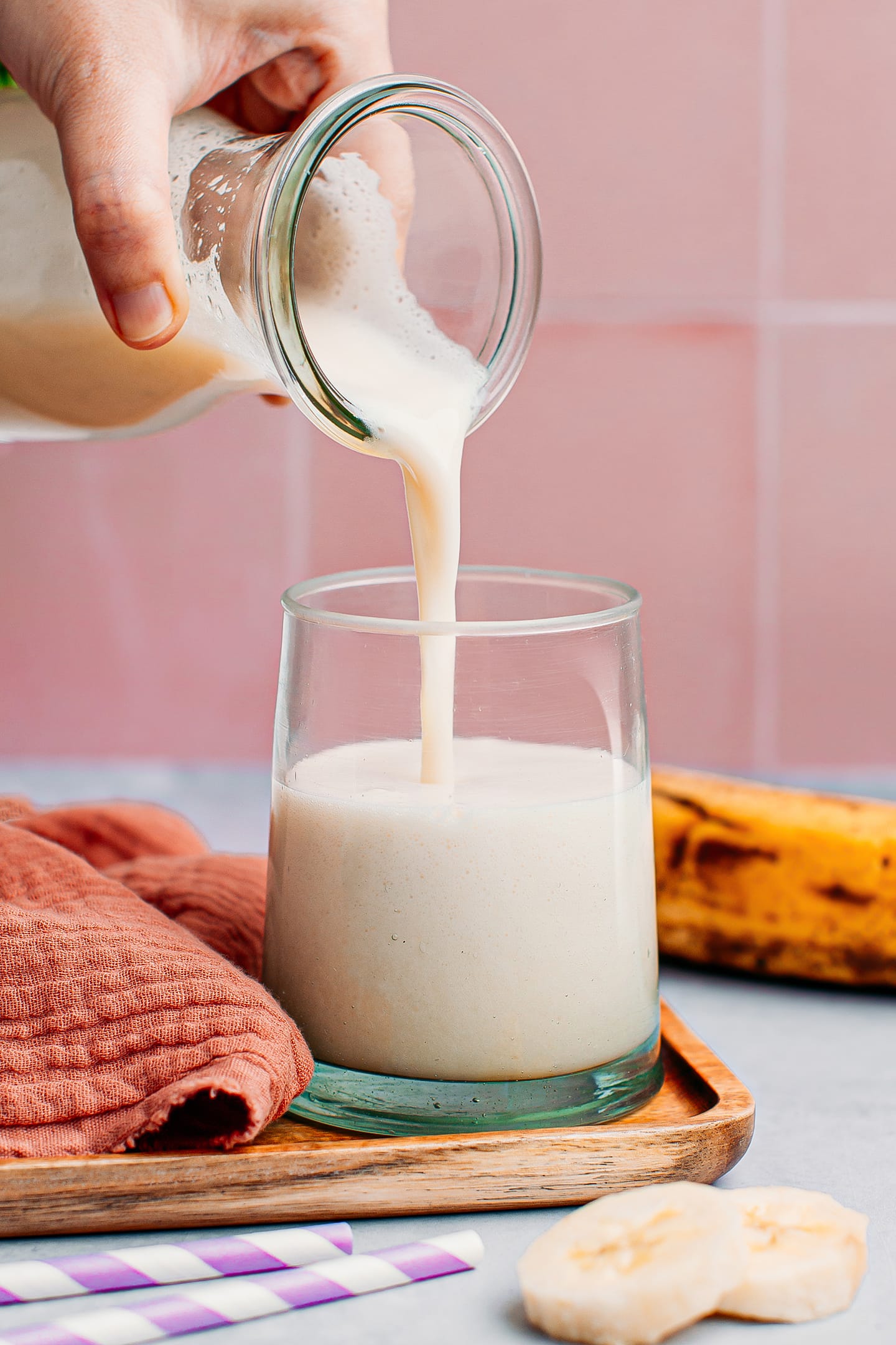 Pouring banana milk into a glass.