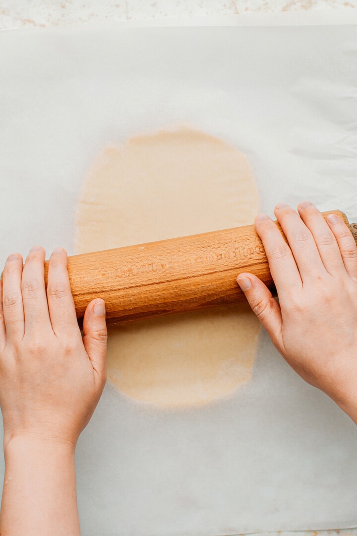 Rolling out dough using a rolling pin.