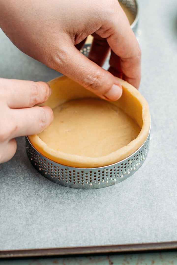 Pressing dough into a tart ring.