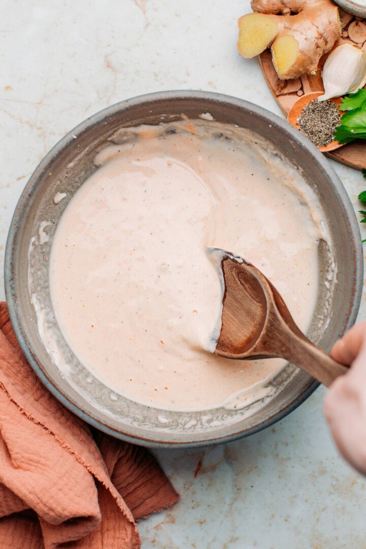 Stirring flour and water in a bowl.