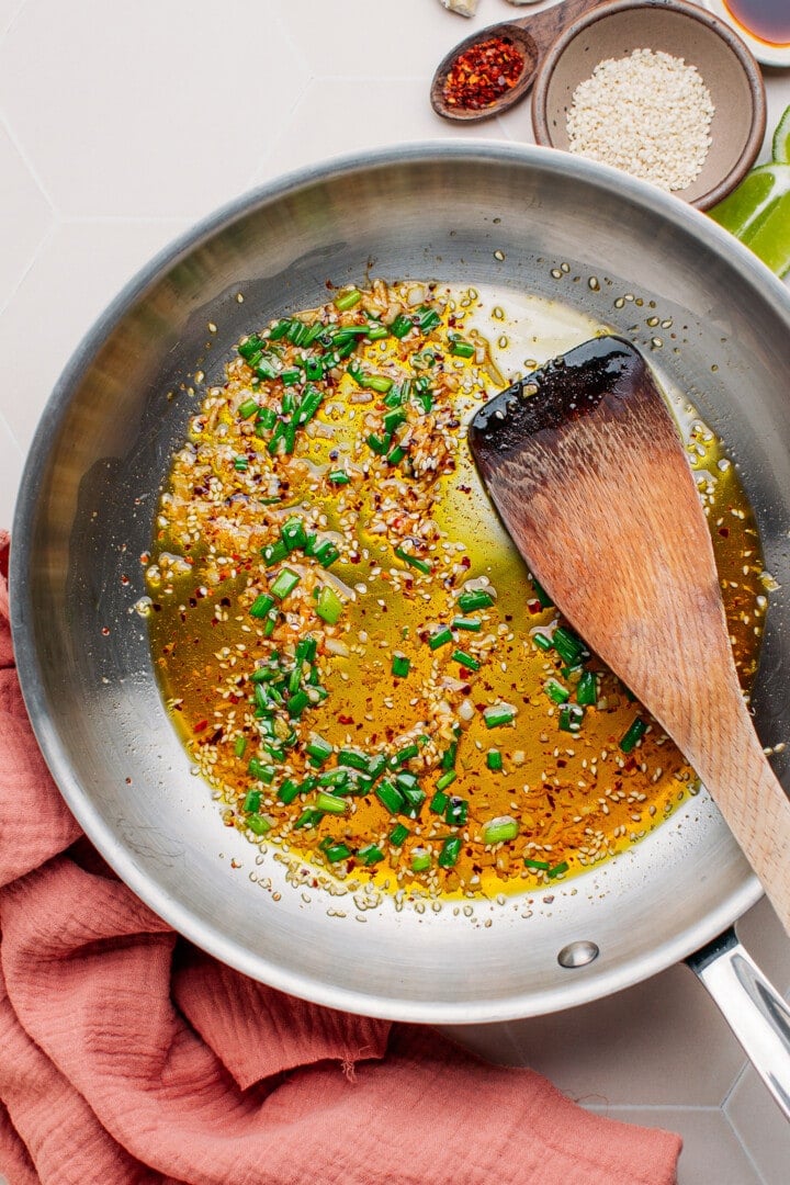 Ginger, garlic, scallions, and sesame seeds in a skillet.