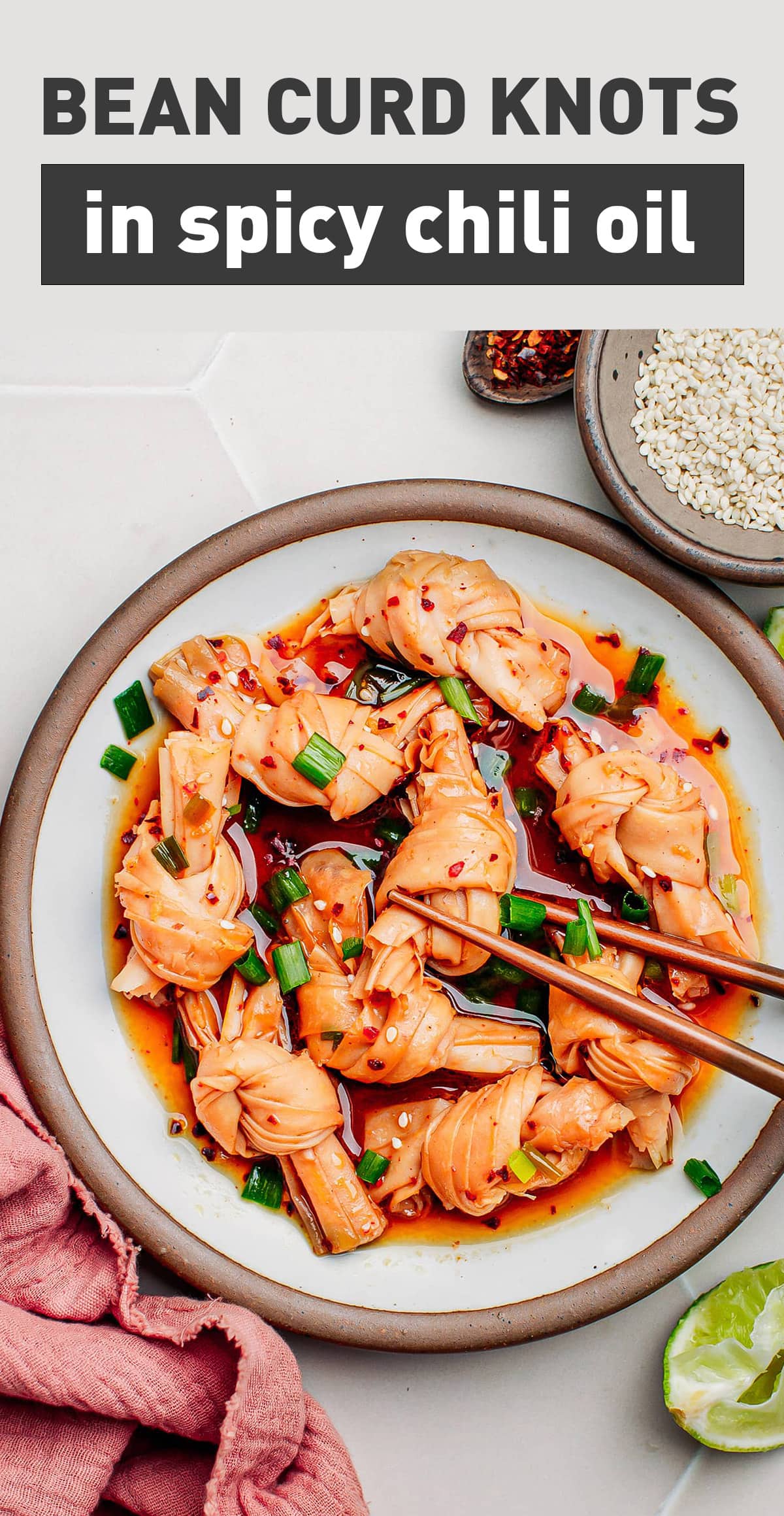 These bean curd knots are sautéed in spicy and garlicky chili oil, and topped with toasted sesame seeds and scallions! Chewy and superbly seasoned, they pack over 20g of protein per serving! #vegan #plantbased #chilioil #spicy