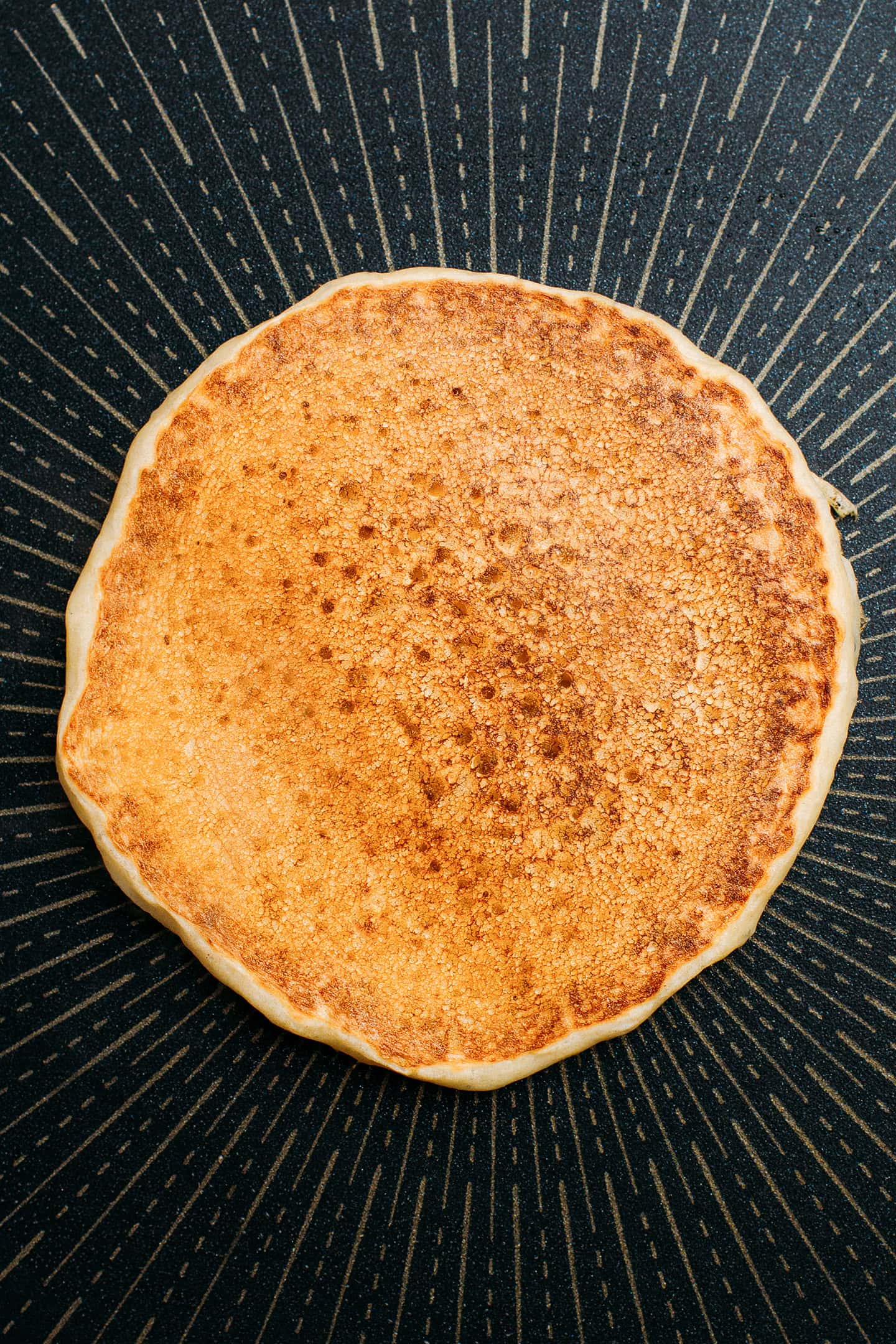 Cooked pancake on a non-stick pan.