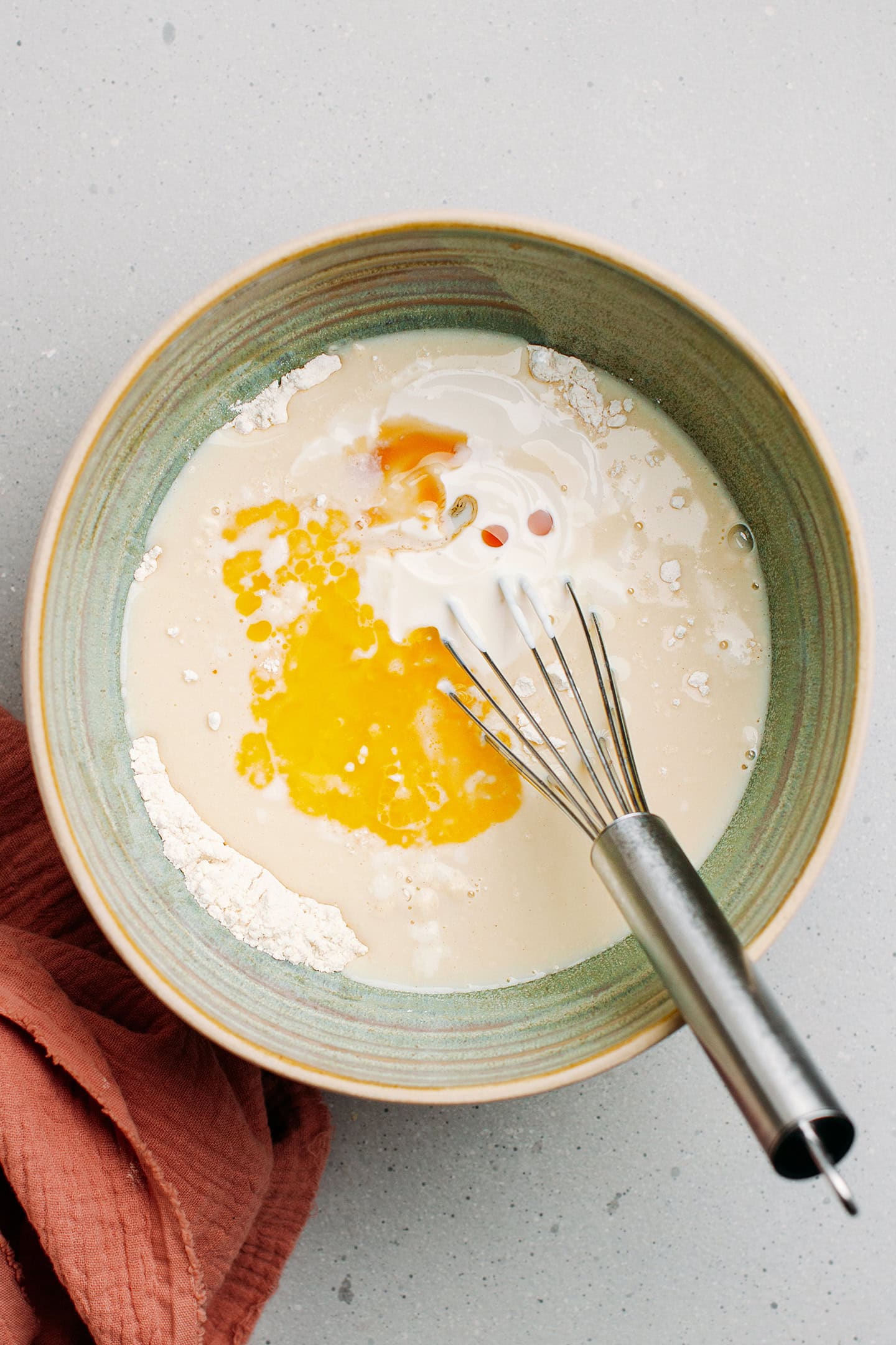 Pancake batter with melted butter and milk in a mixing bowl.