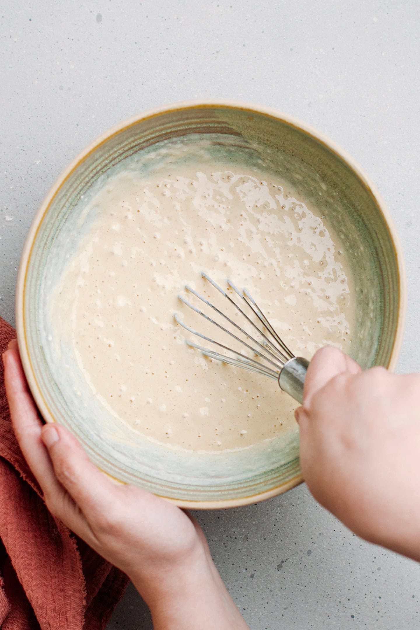 Whisking pancake batter in a bowl.