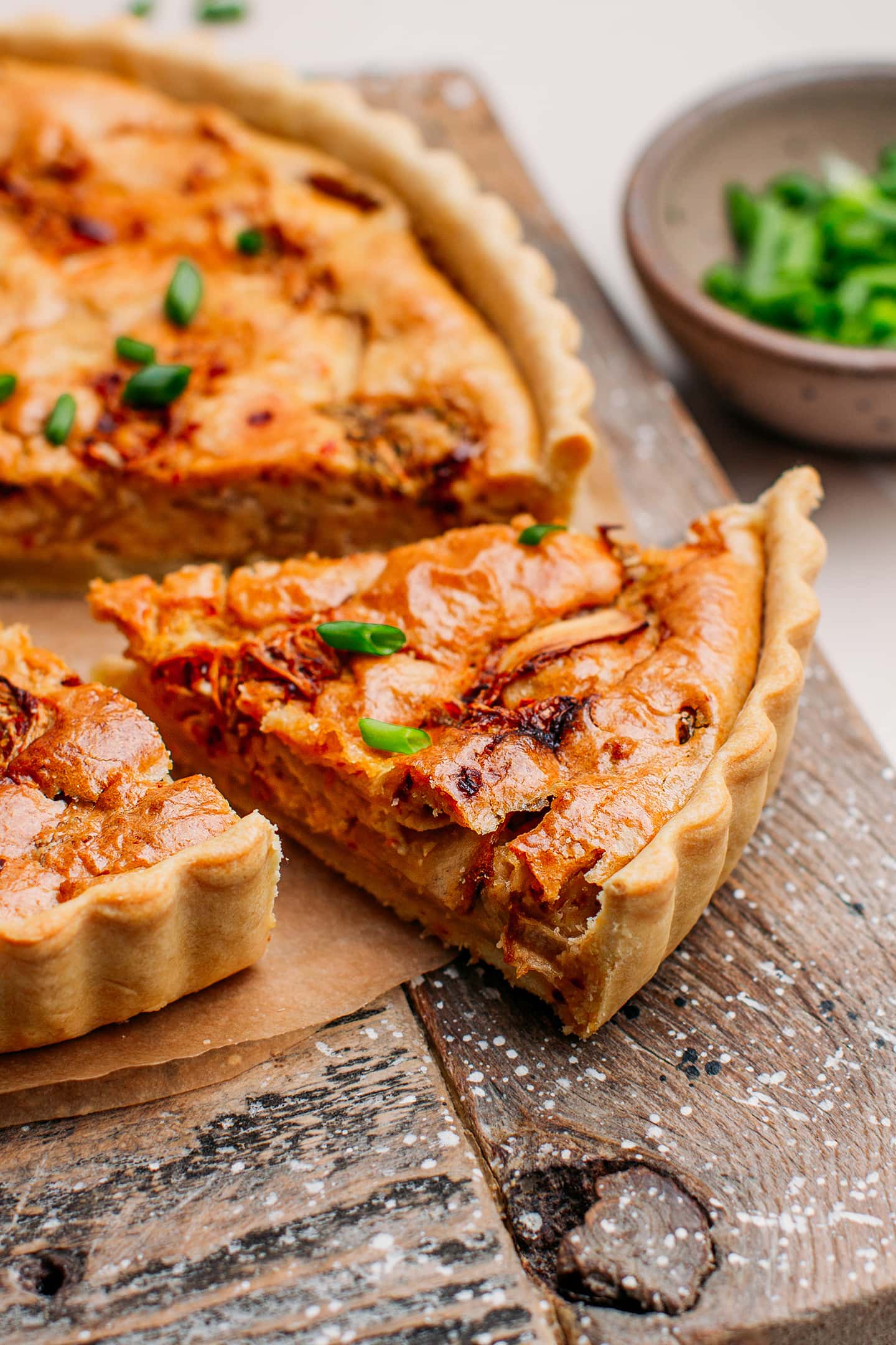 Slice of vegan kimchi quiche on a cutting board.