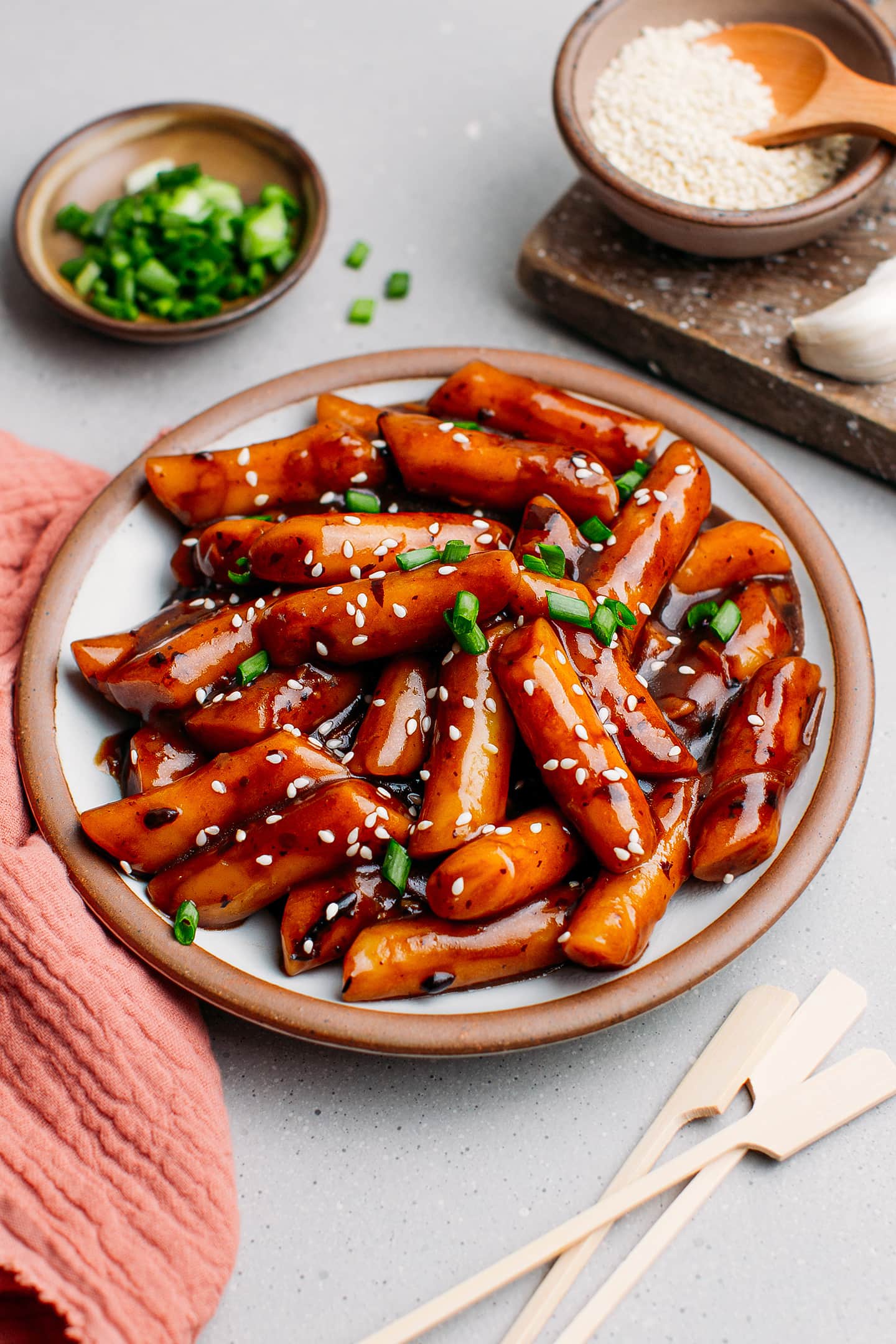 Jjajang Tteokbokki with black bean sauce and scallions on a plate.