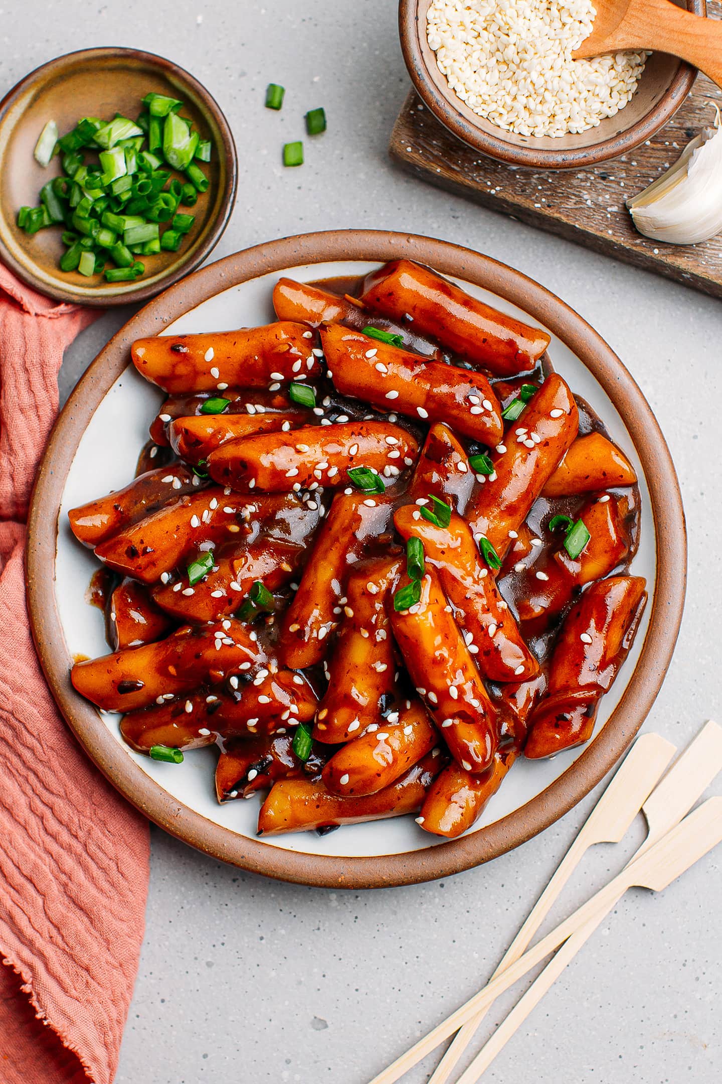 Tteokbokki with black bean sauce and scallions on a plate.