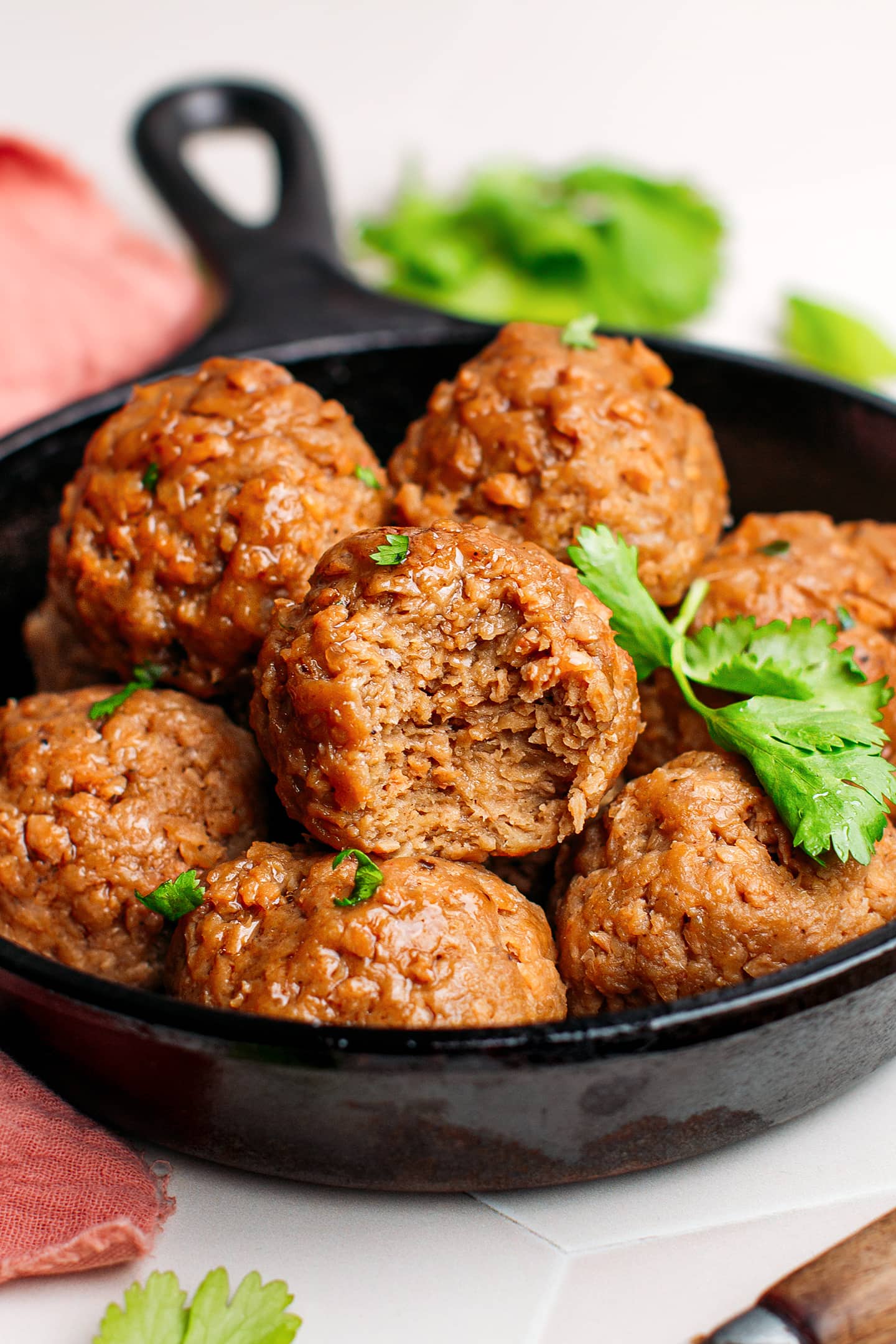 Bite of a vegan meatball in a skillet.