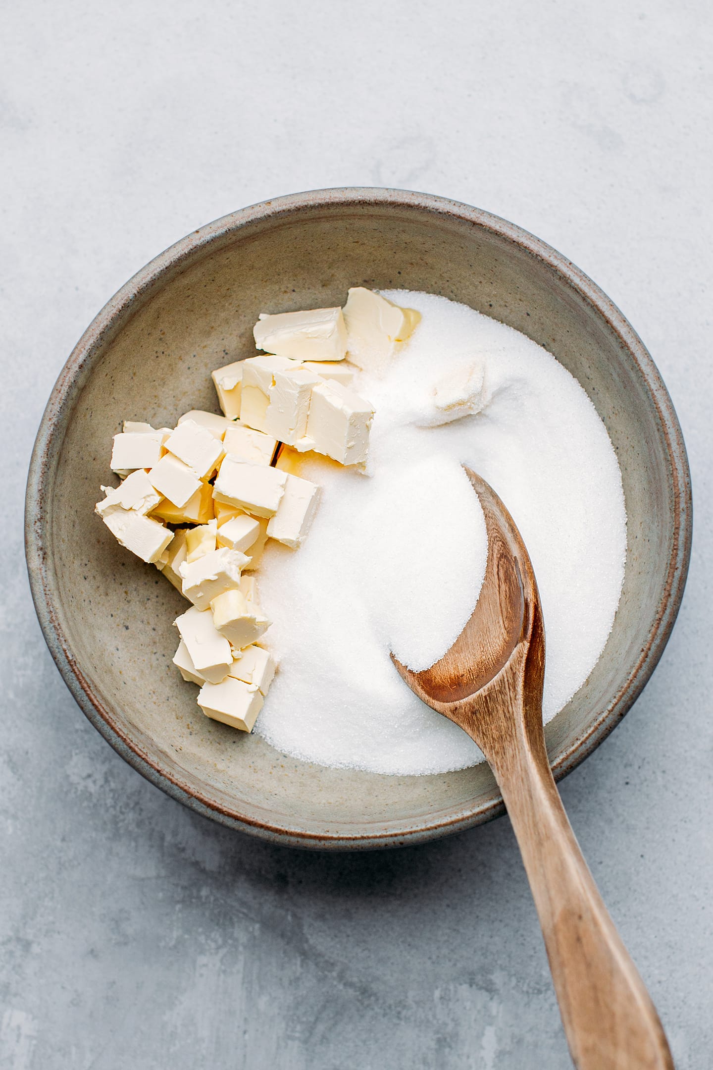 Diced butter and sugar in a mixing bowl.