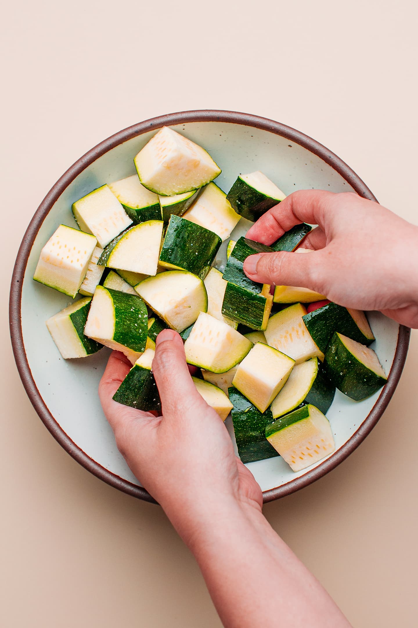 Coating diced zucchini with salt.