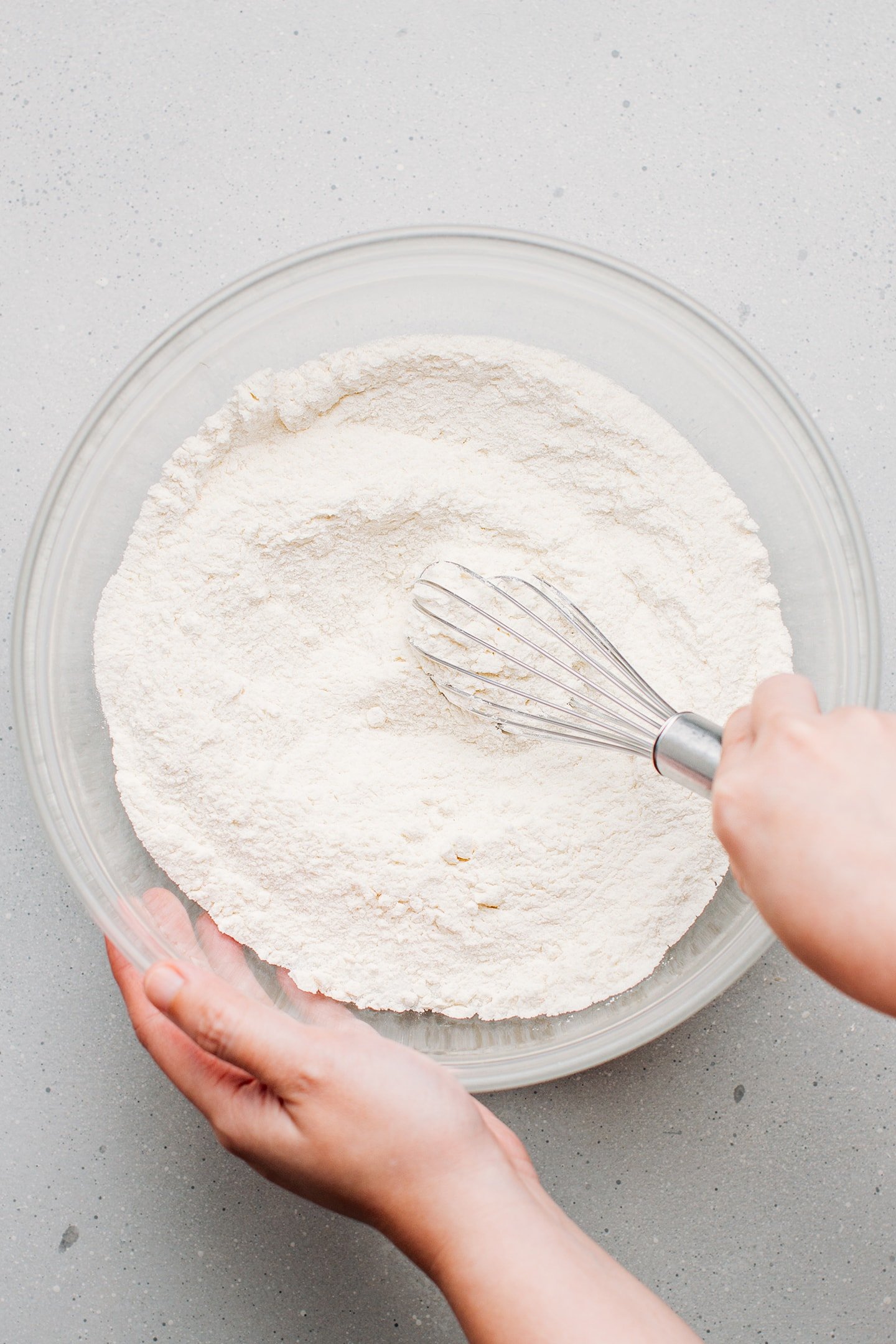 Whisking flour and sugar in a mixing bowl.