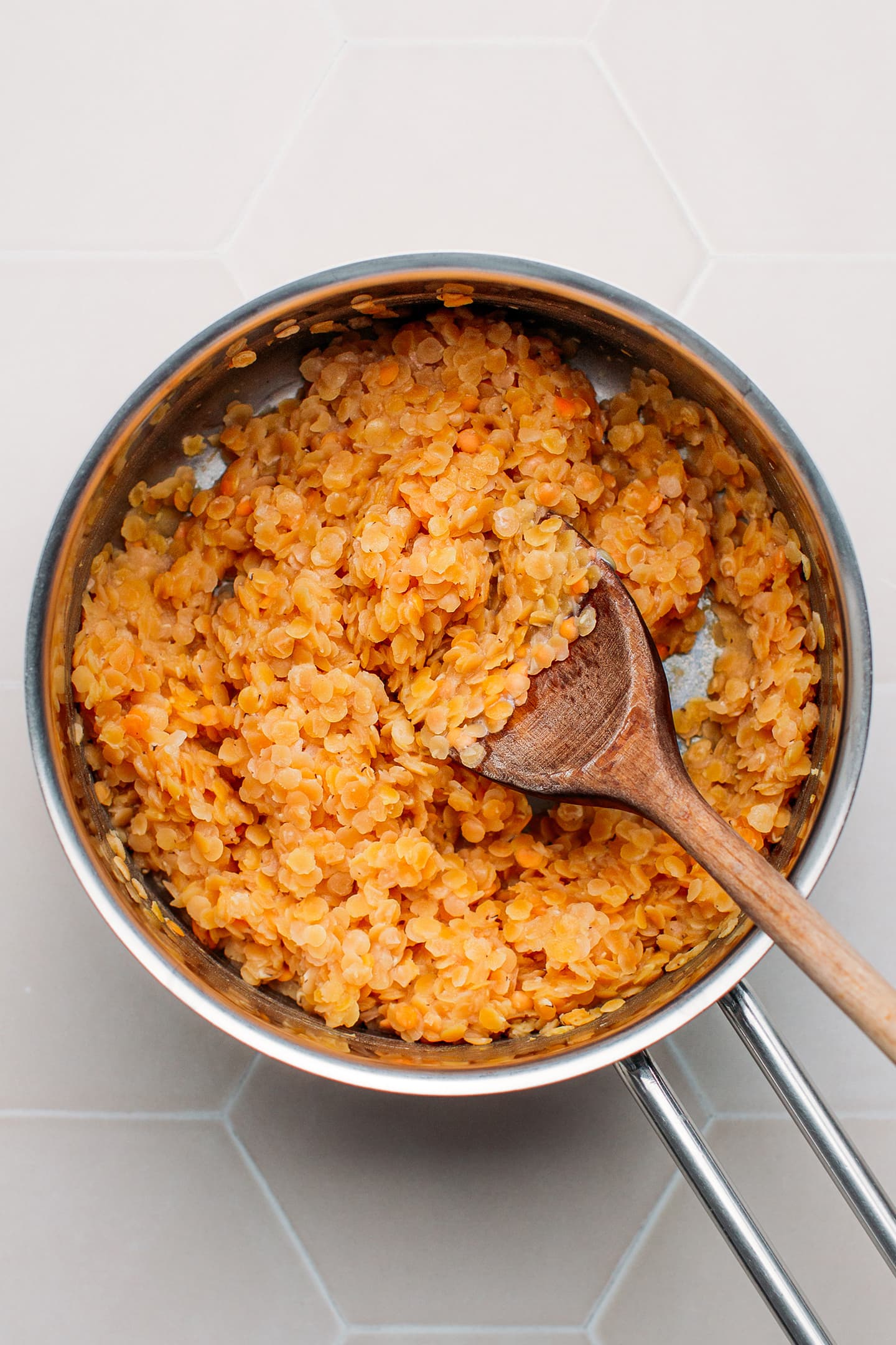 Cooked red lentils in a saucepan.