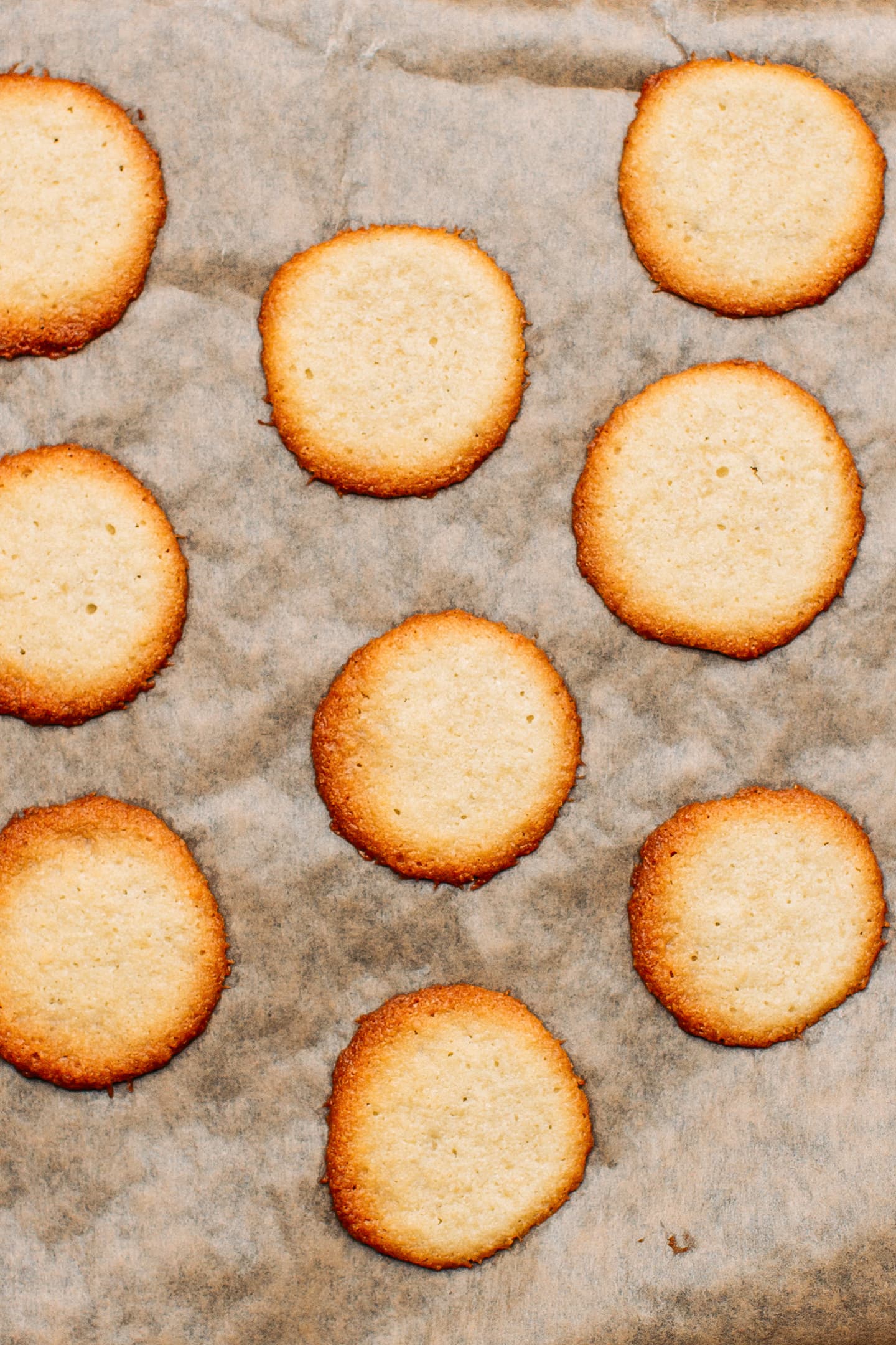 Baked cookie thins on a baking sheet.