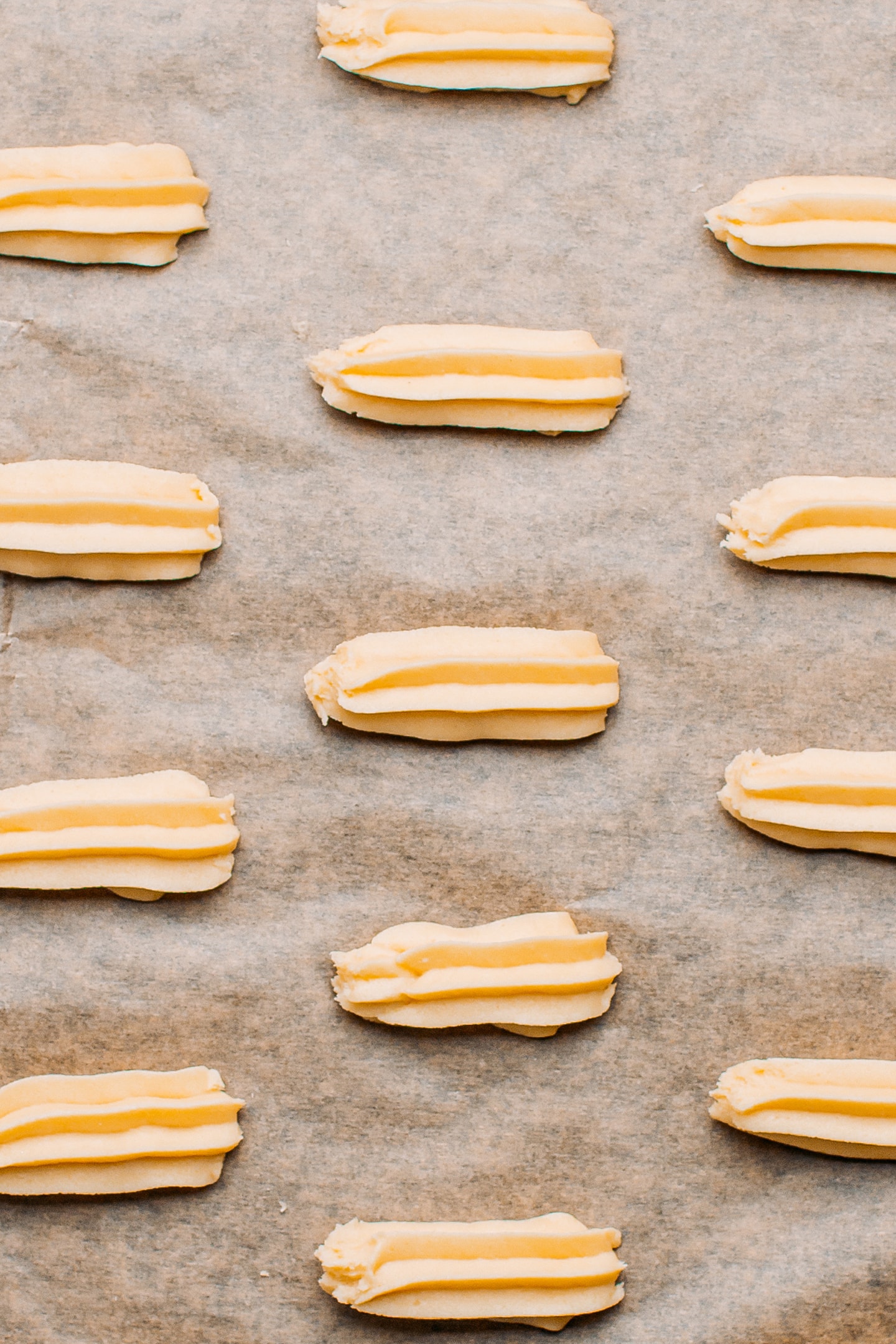 Unbaked spritz cookies on a baking sheet.