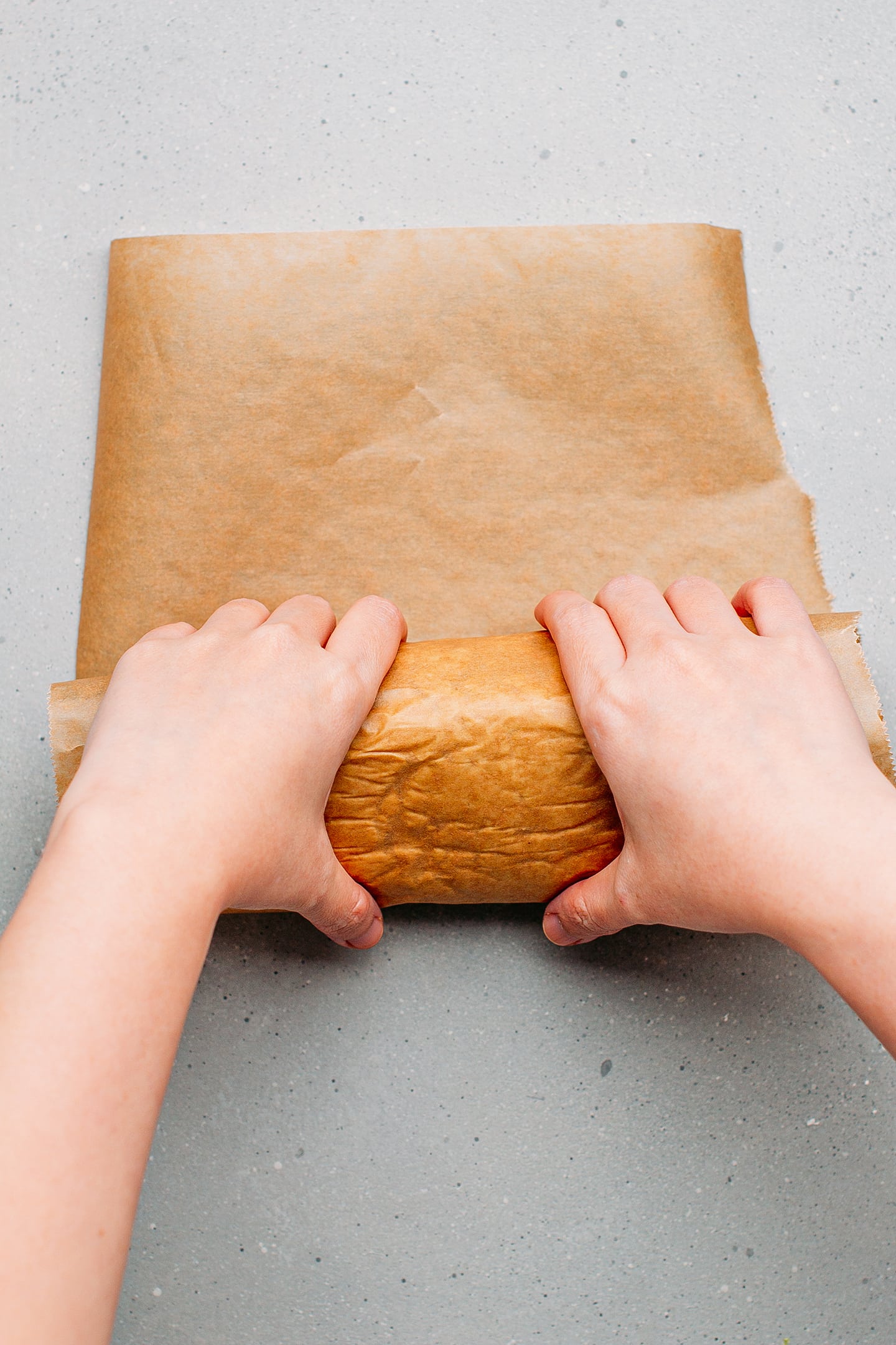 Rolling vegan bologna in a piece of parchment paper.