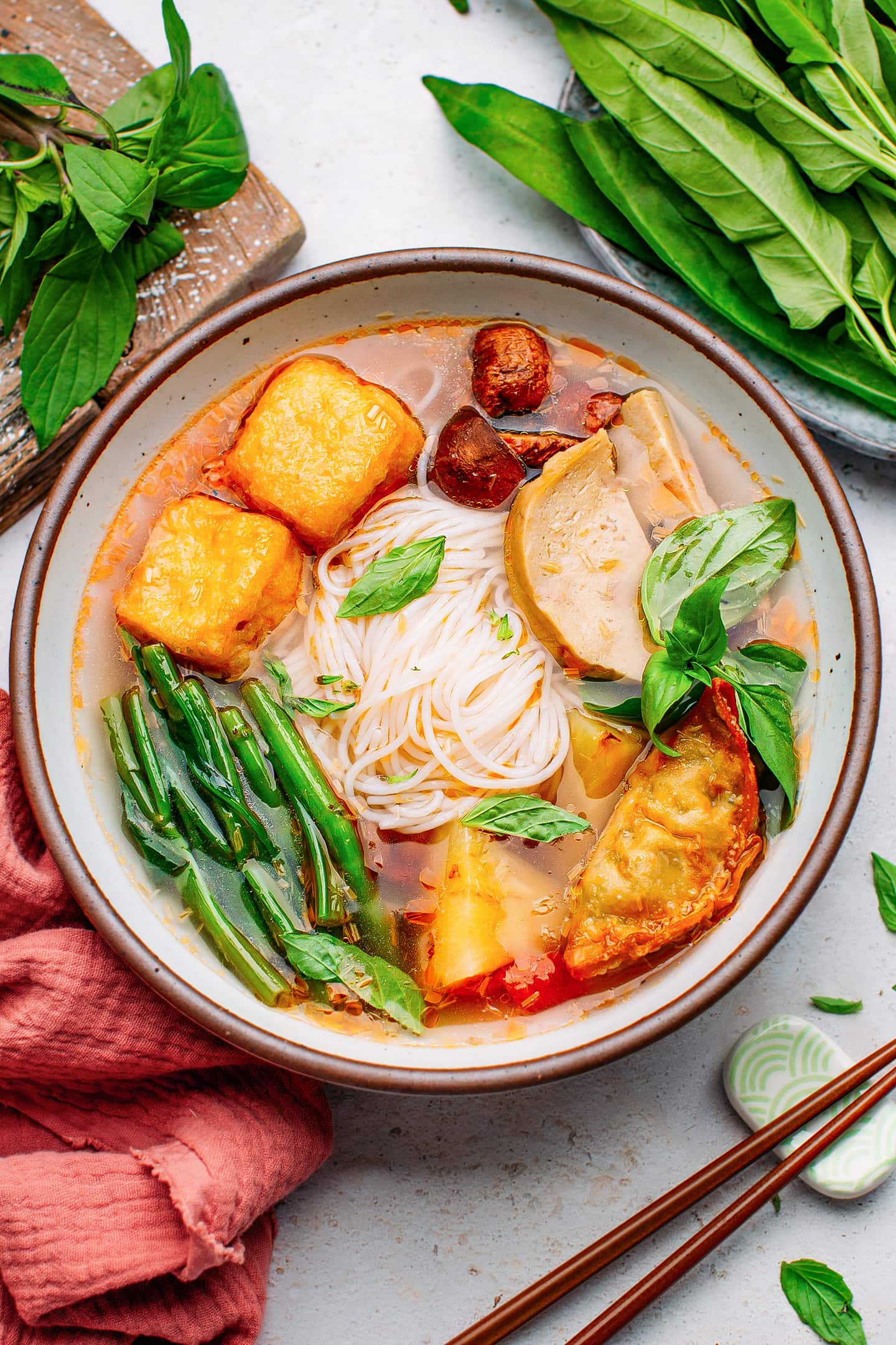 Hot and sour soup with tofu, rice noodles, and fresh herbs.