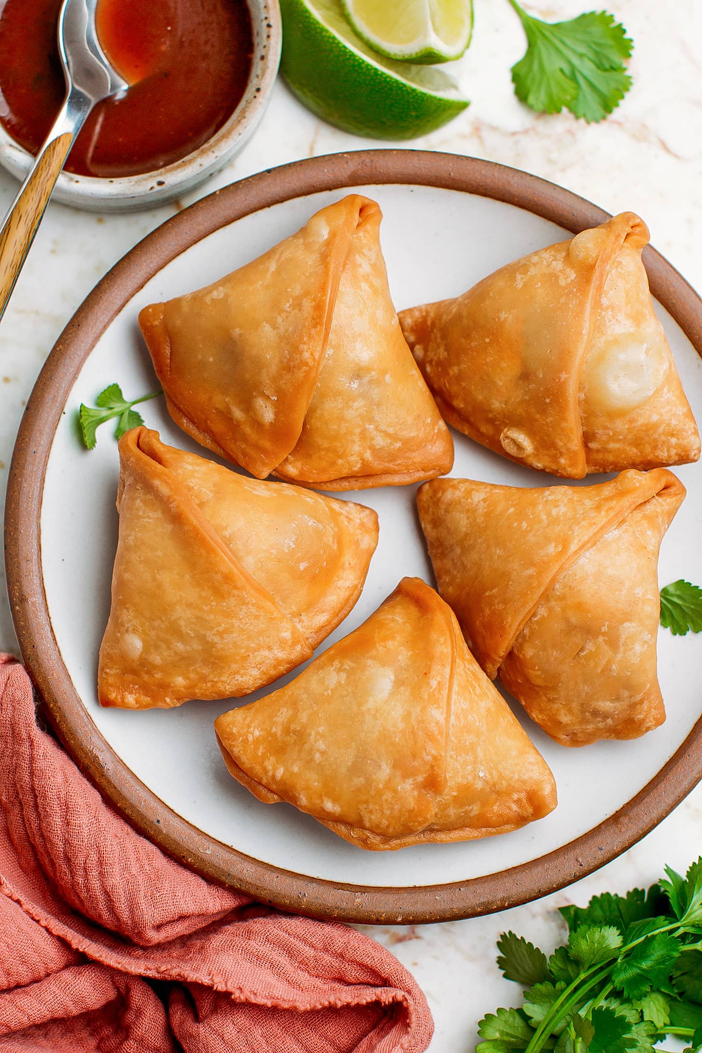 Vegan samosas on a small serving plate.