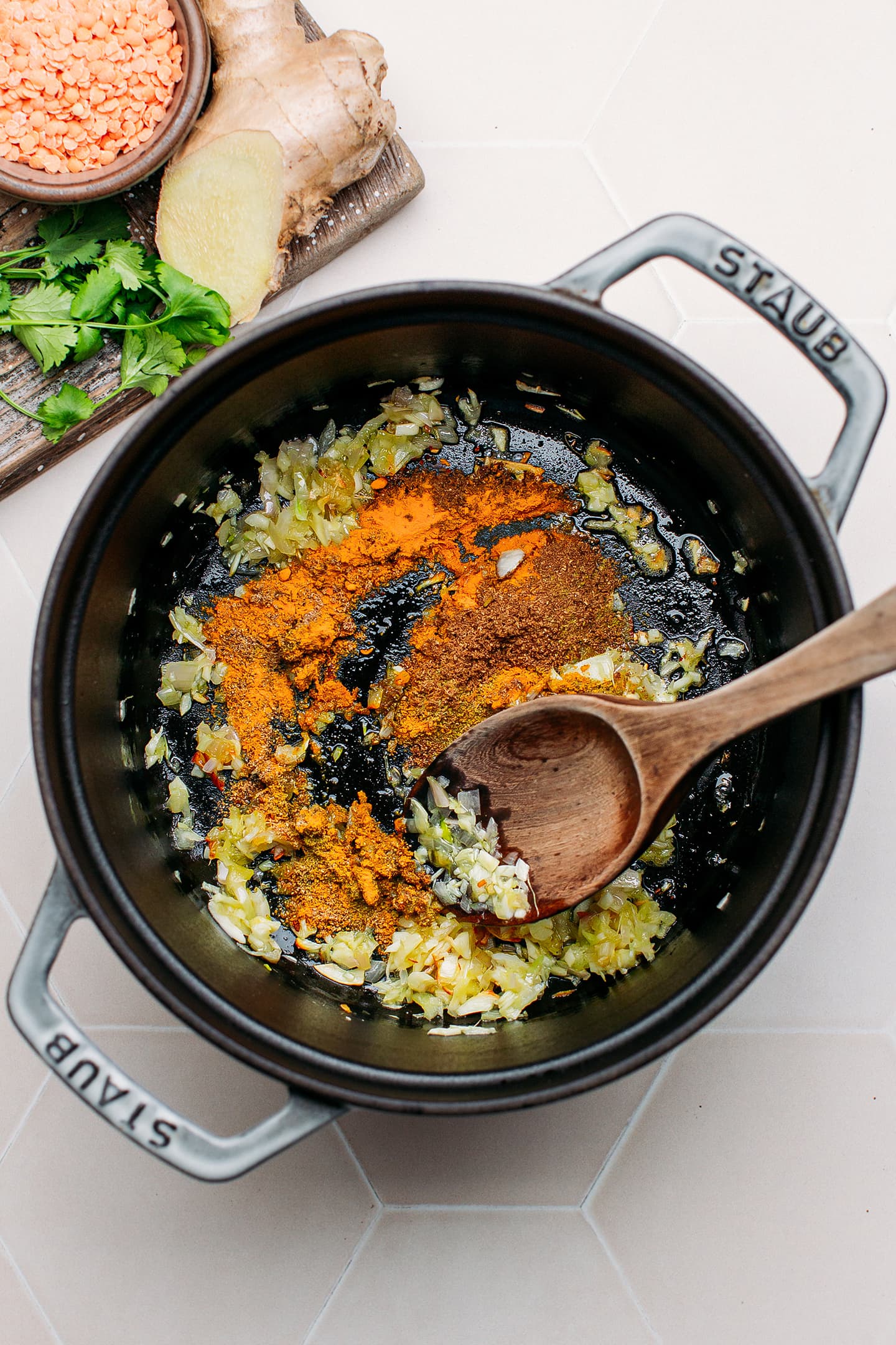 Shallots, ginger, and spices in a pot.