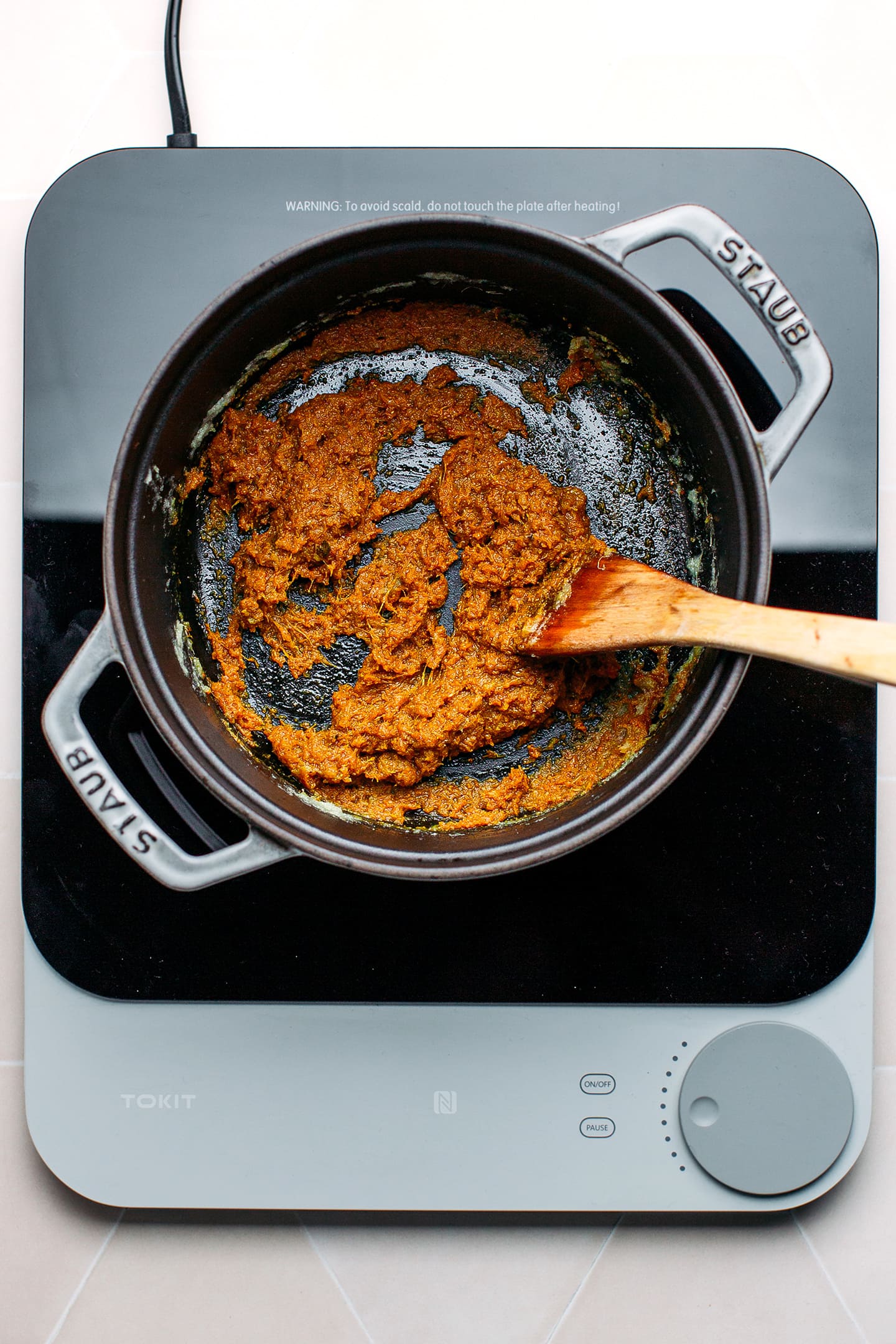 Stir-frying curry paste in a pot.