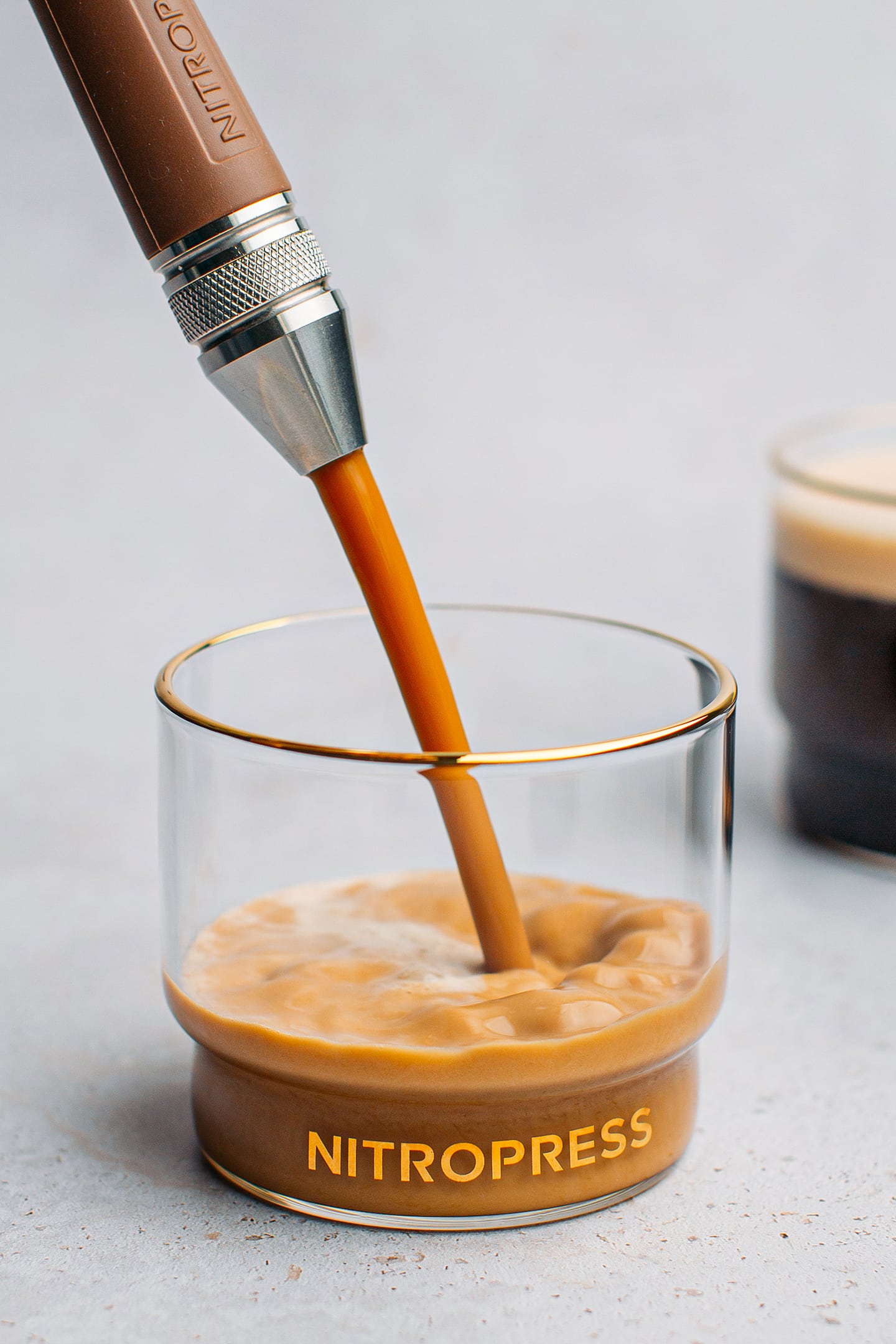 Pouring nitro cold brew into a glass through a dispenser.