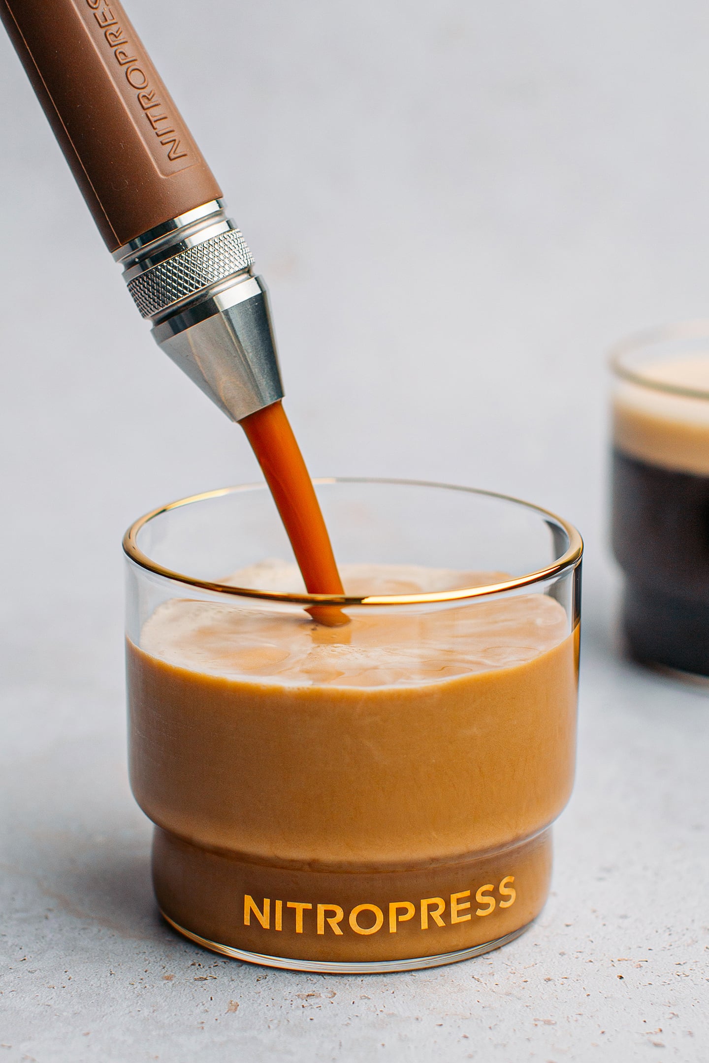 Pouring nitro cold brew into a glass through a dispenser.